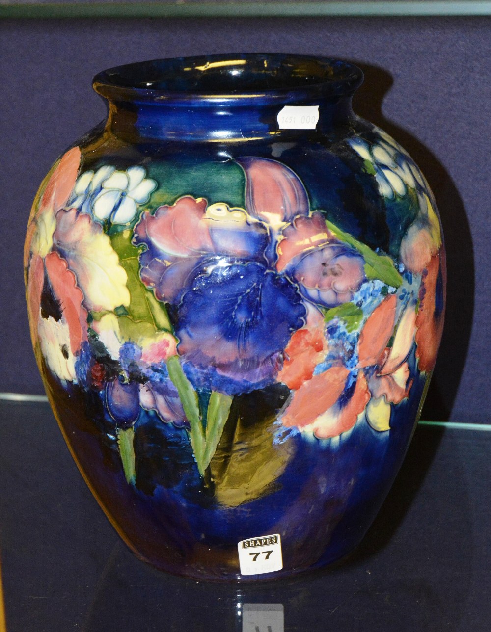 A large Moorcroft vase decorated with flowers over blue ground, signed and stamped to base (