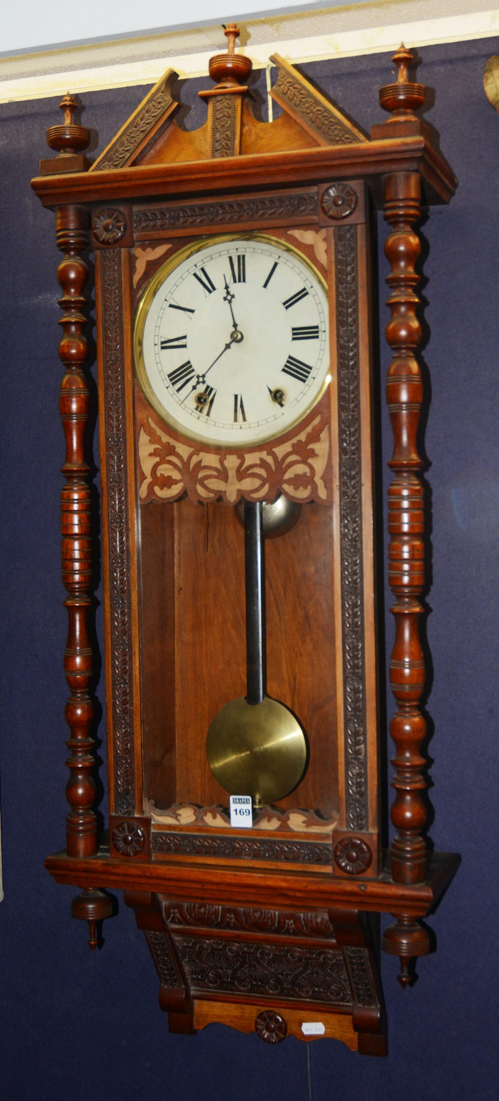 A 19th century walnut Vienna clock, with eight day movement striking bell, the broken pediment