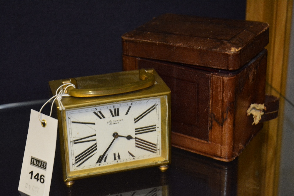 A brass carriage clock by J Ball & Co Ltd, mounted by handle, rectangular white face, Roman