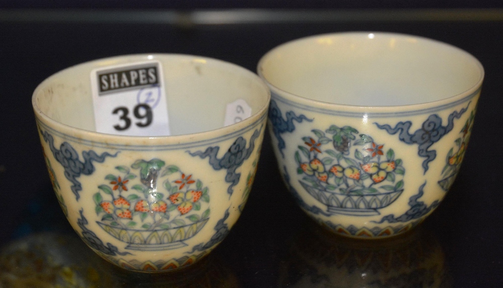 A pair of famille vert tea cups, decorated with flowers, signed to underside (2)