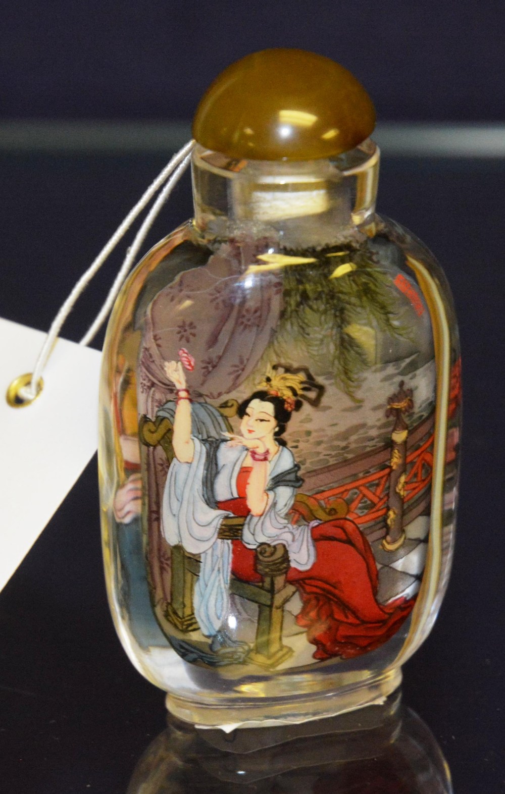 An oriental scent bottle, painted to the inside, depicting young ladies, 8.5cm high