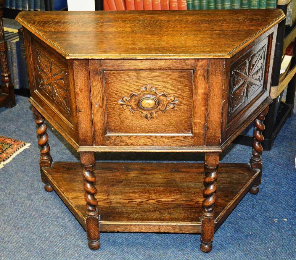 An oak cabinet, of chamfered  moulded top, panelled door on barley twist legs, bun feet, united by