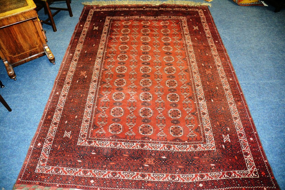 A Bukhari carpet, with three rows of ten guls, on red ground and various borders, 313 x 200cm