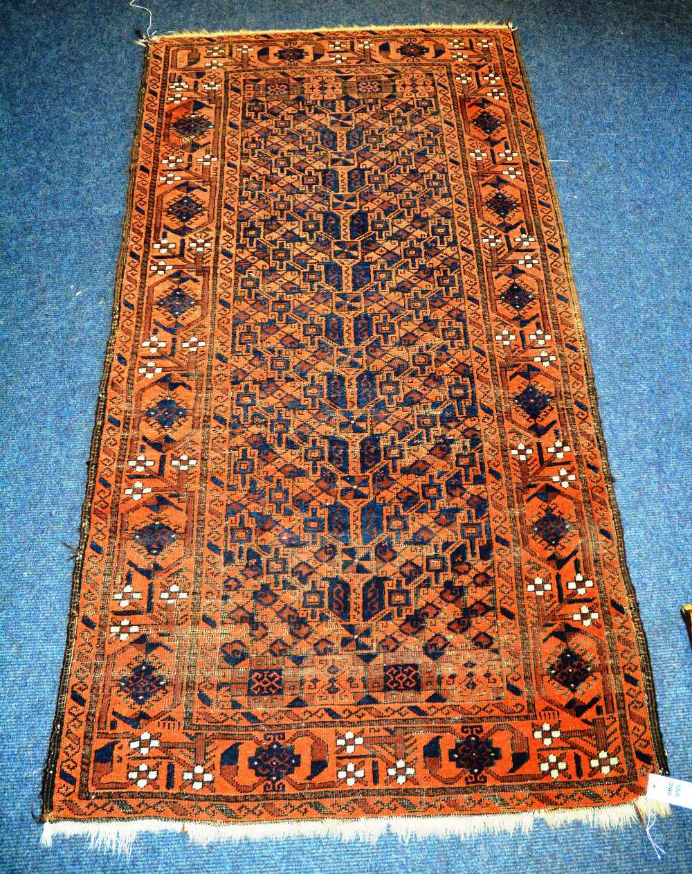 A Persian rug, with overall geometric design and border, 178 x 93cm