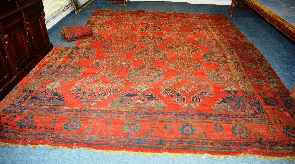 A Turkish carpet, with allover dog tooth and cruciform medallions over red ground and borders (