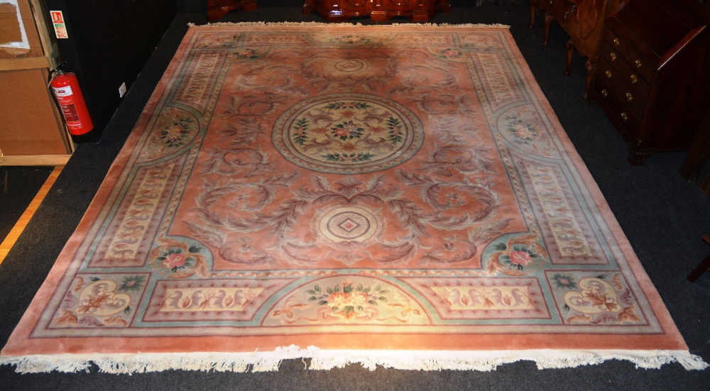 A large Kayam carpet with overall foliate design on pink ground, 455 x 350cm