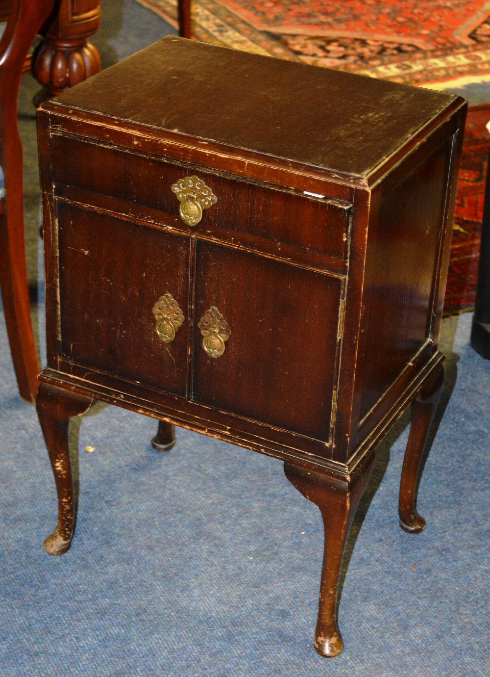 A mahogany pot cupboard, the moulded rectangular top over frieze drawer, doors raised on cabriole