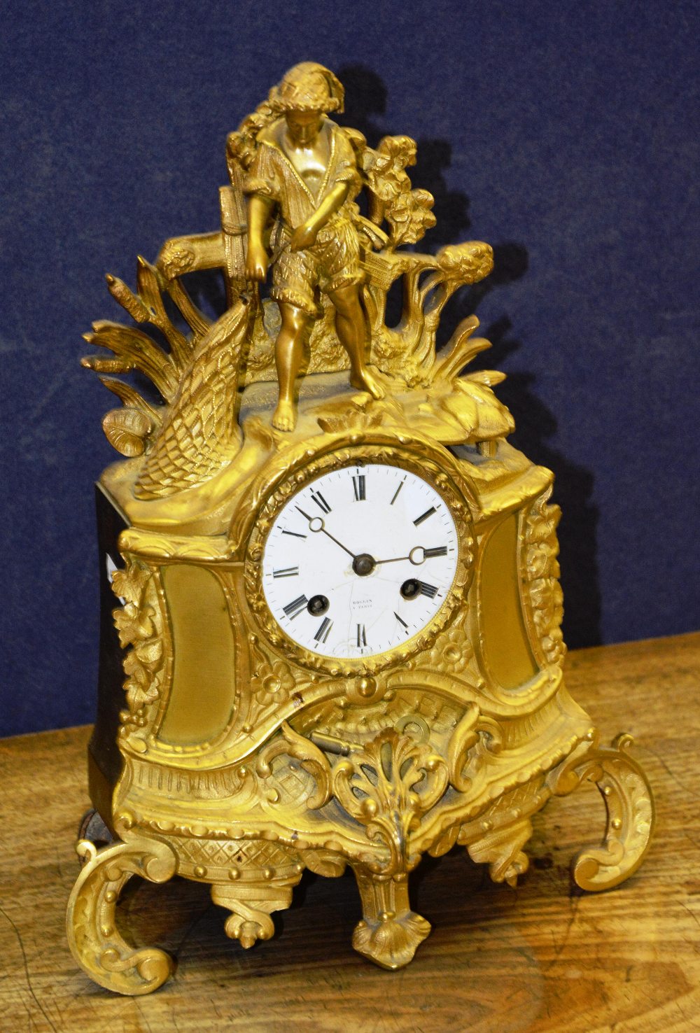 A French gilt metal mantle clock by Rollin of Paris, mounted by fisherman pulling in the net