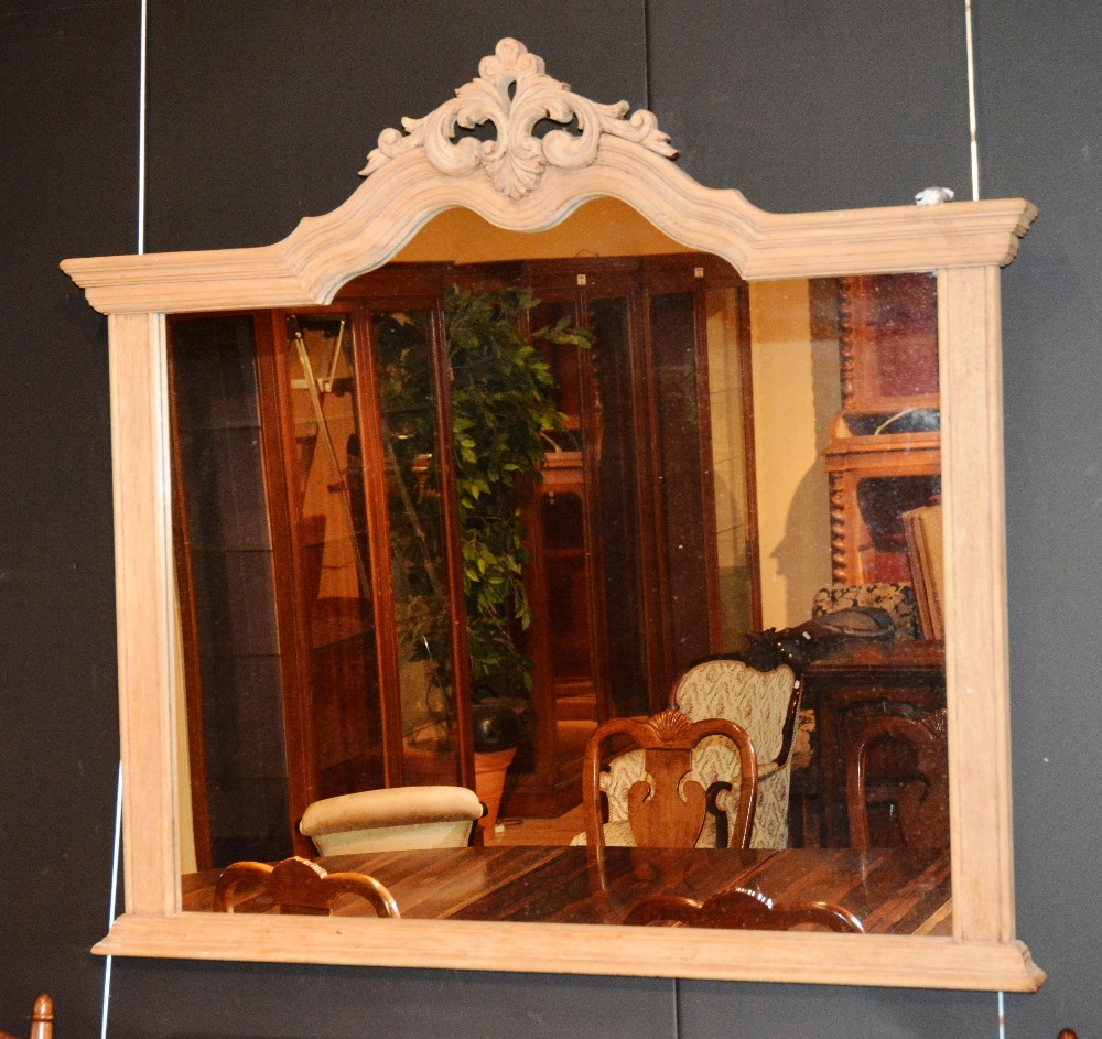 A stripped mahogany over mantle mirror, the moulded arched frame mounted by floral finial, 119cm