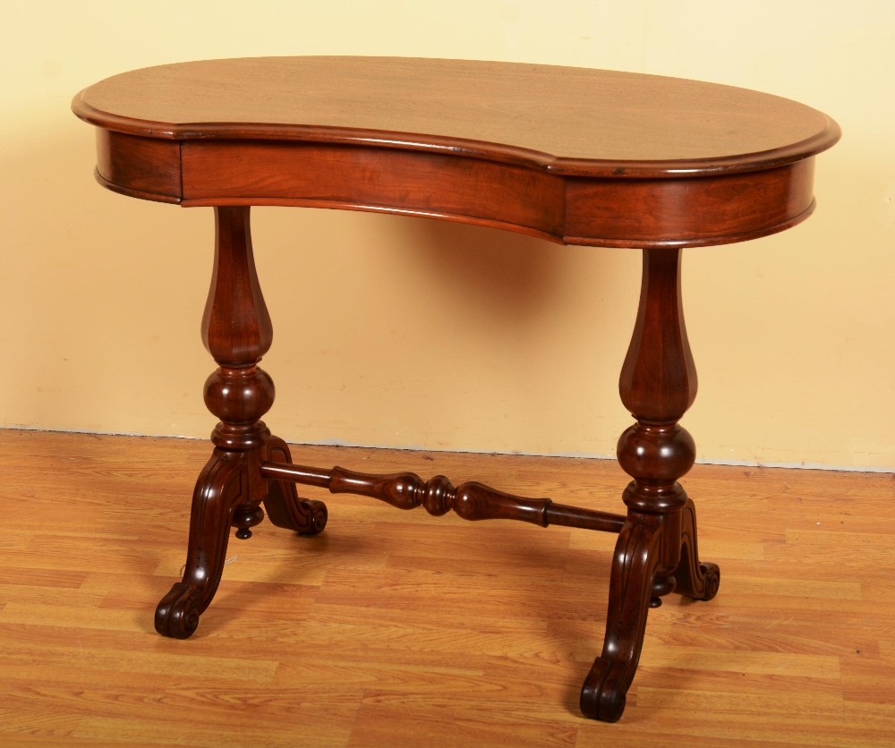 A Victorian mahogany kidney shaped desk, the moulded top over concealed frieze drawer, raised on