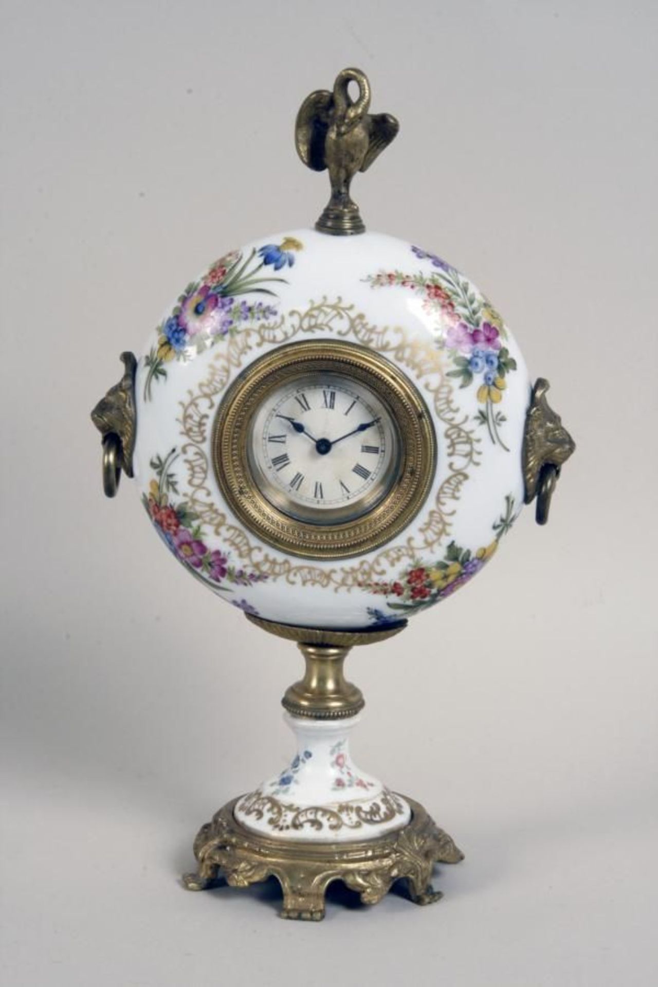 A PROCELAIN CLOCK ca. 1900 Round porcelain case with coloured painted flower bouquet and gold decor,