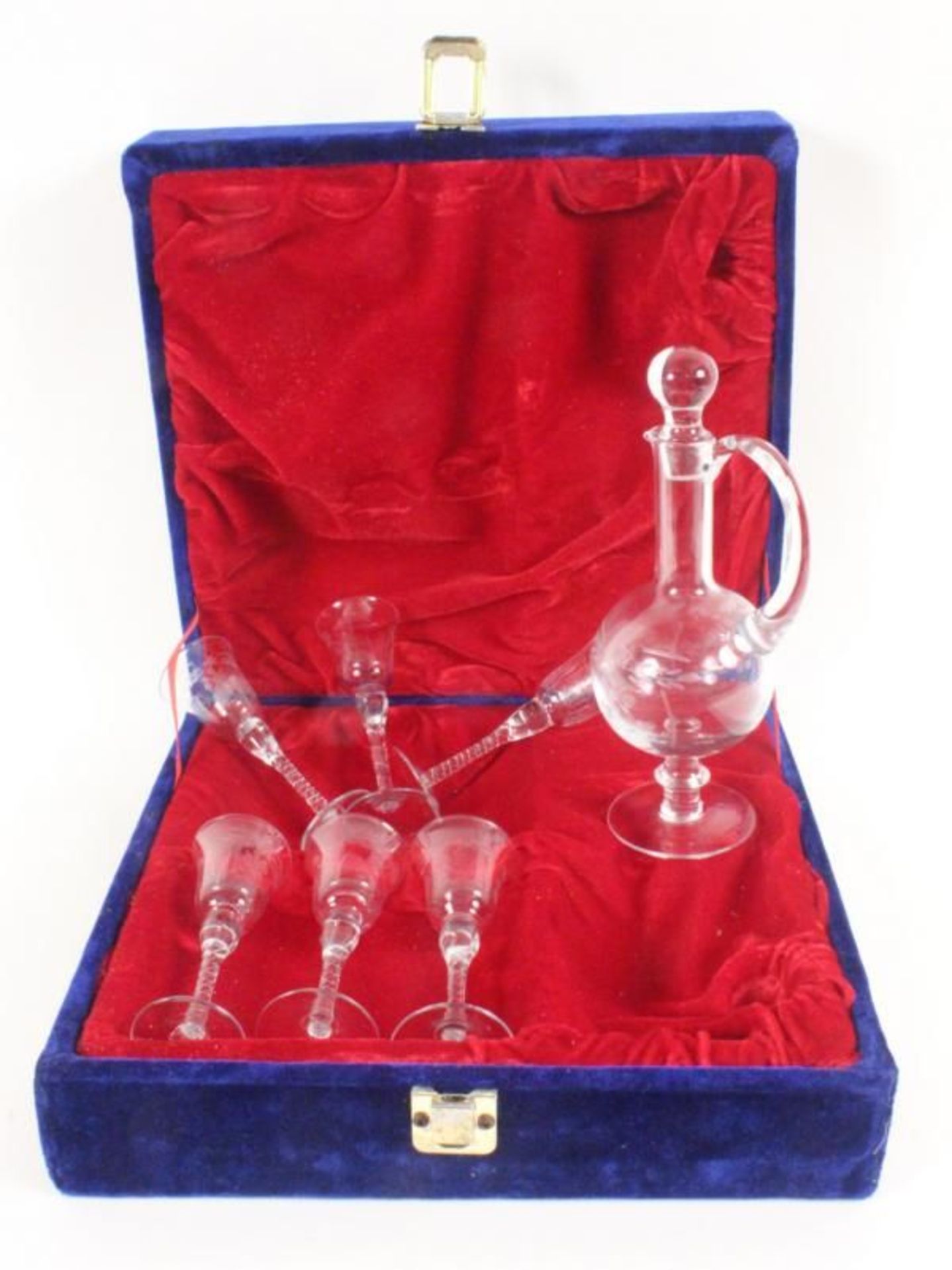 A LIQUEUR SET IN A CASKET Colourless glass with cut decor, comprising a decanter with stopper and
