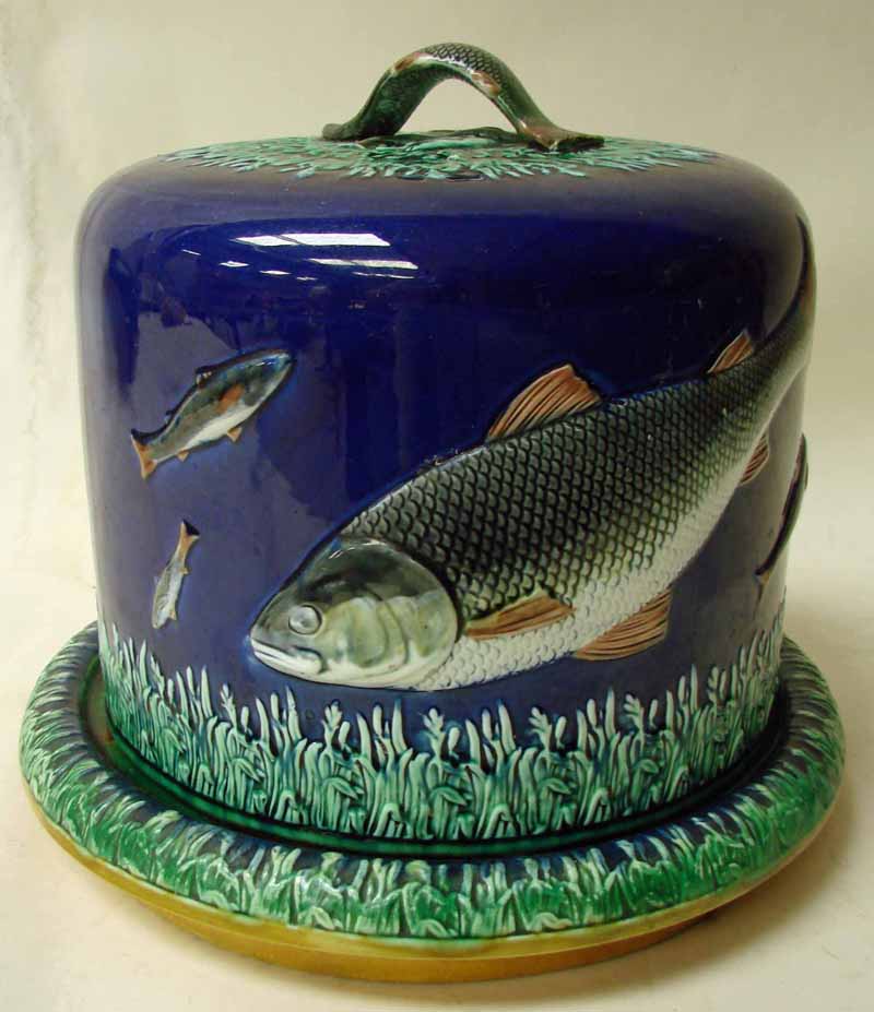 A 19th century majolica cheese stand, the dome shape cover decorated in relief with swimming fish