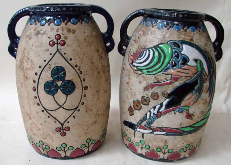 A pair of Amphora Austria two handled vases of ovoid form, decorated in bright enamels with