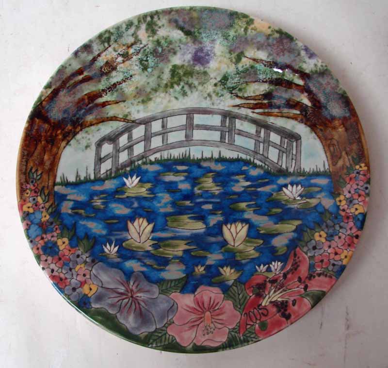 A Cobridge pottery year plate 2005, of circular form with a Monet style lily pond scene by Samantha