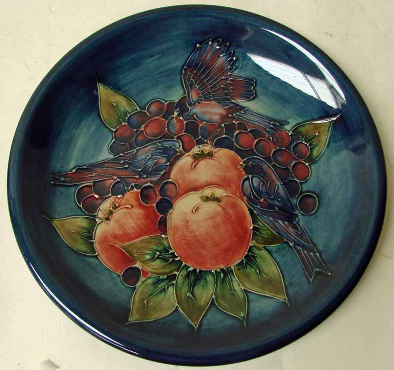 A Moorcroft pottery plate of circular form, tubeline decorated in the Finches design, impressed