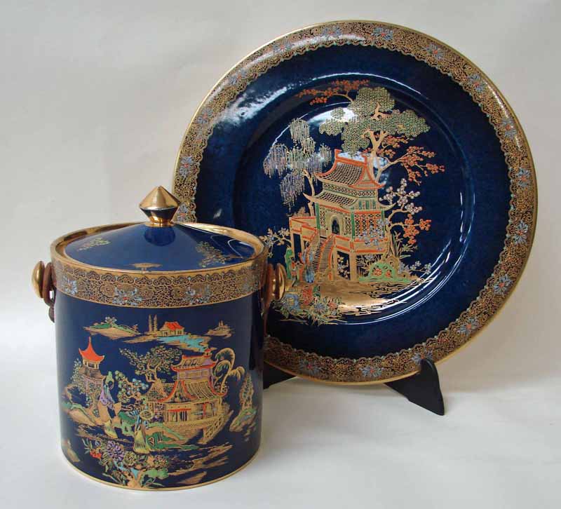 A Carlton ware lidded biscuit barrel of cylindrical form with a cane handle, decorated in the