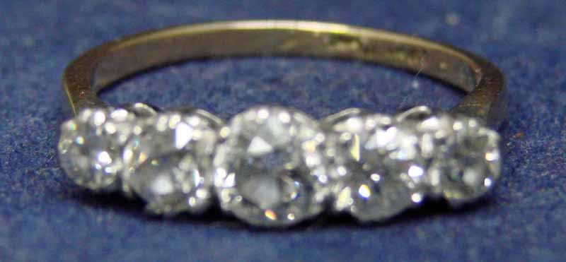 An 18ct gold and platinum set five stone diamond ring, approx 1.1ct of claw set graduated old cut