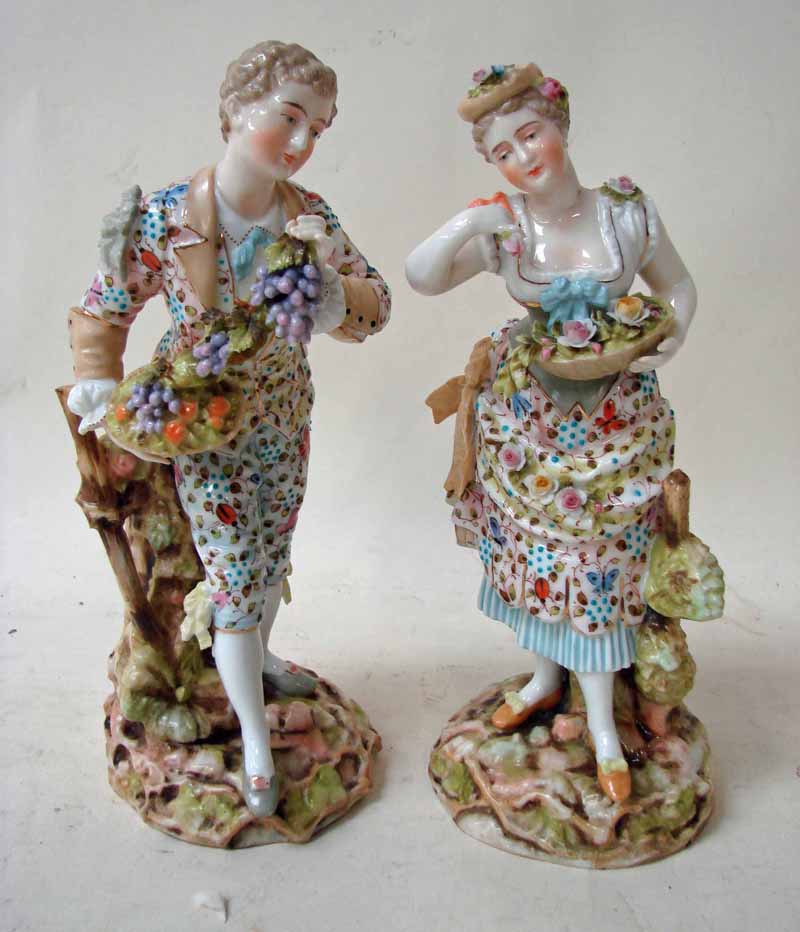 A pair of 19th century Volkstedt porcelain figures of grape and flower gatherers dressed in 18th