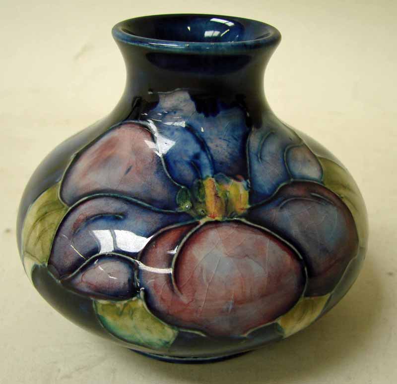 A Moorcroft pottery small vase of onion form, tubeline decorated in the Clematis design on blue