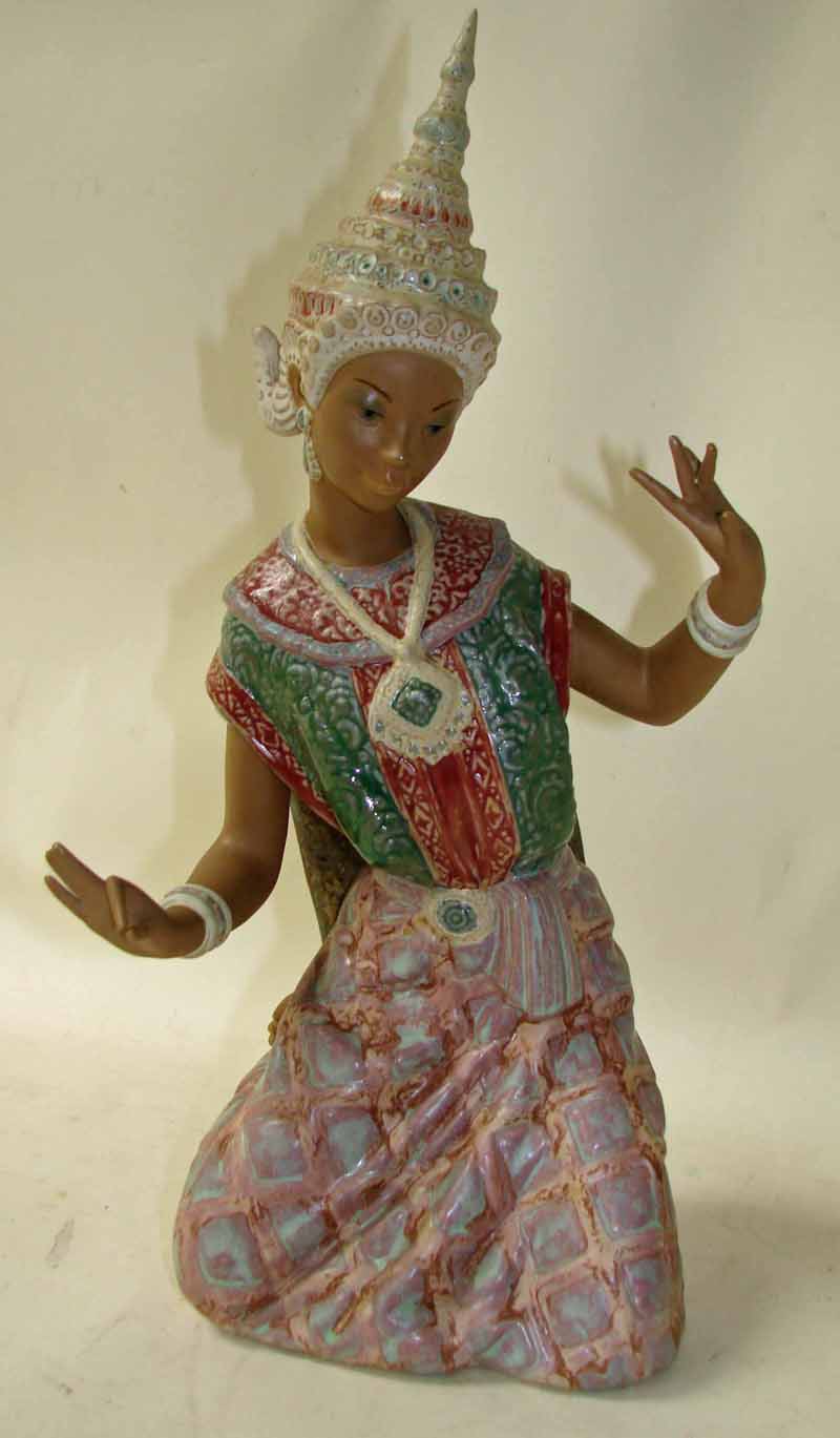 A Lladro pottery figural model as an Indonesian dancer, modelled kneeling wearing traditional