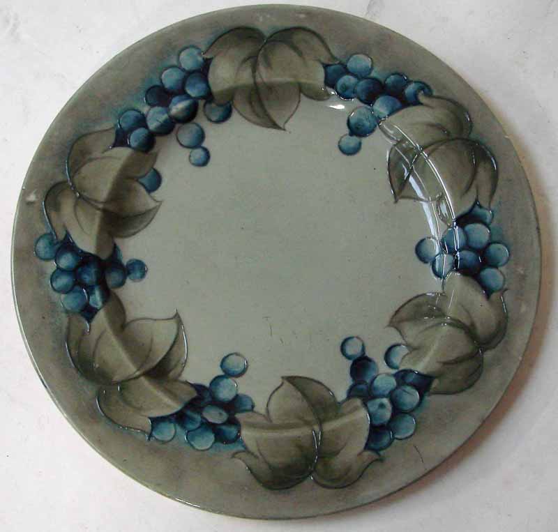 A William Moorcroft plate of rimmed circular form, tubeline decorated in the early Leaf and Grape