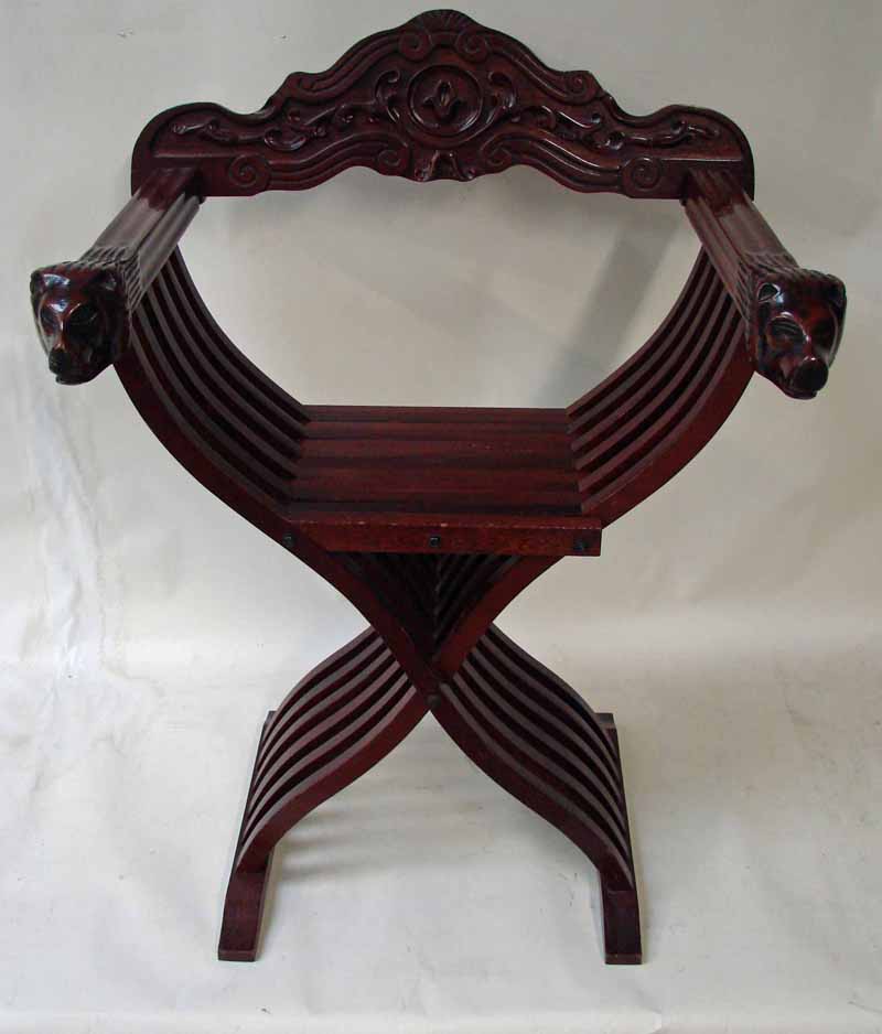A 20th century mahogany Savonorola type folding chair, the carved removable back rail set into