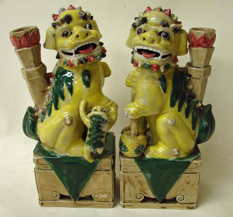 A pair of Chinese pottery Temple Guardians in the form of Lion Dogs, brightly glazed in yellow and