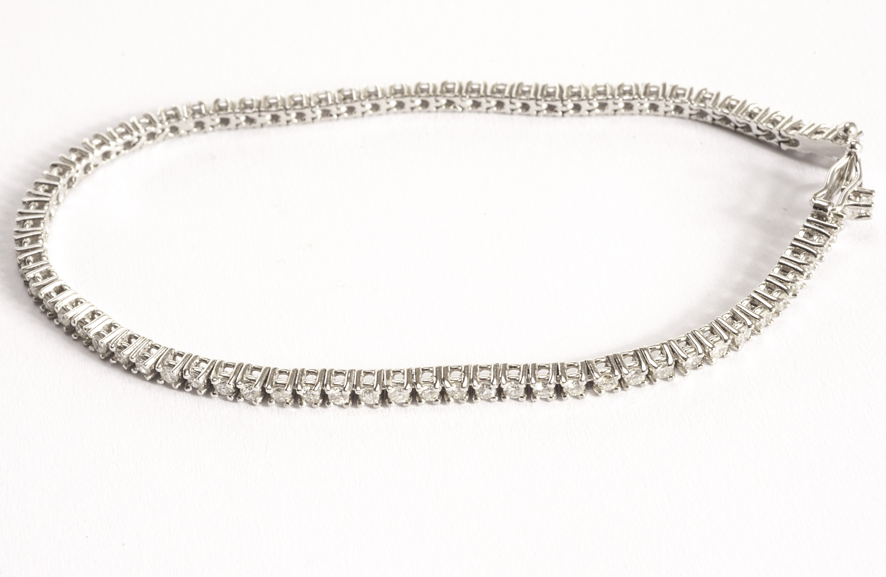 A modern 18ct gold and diamond tennis bracelet, the white gold line bracelet set with approx 2ct of