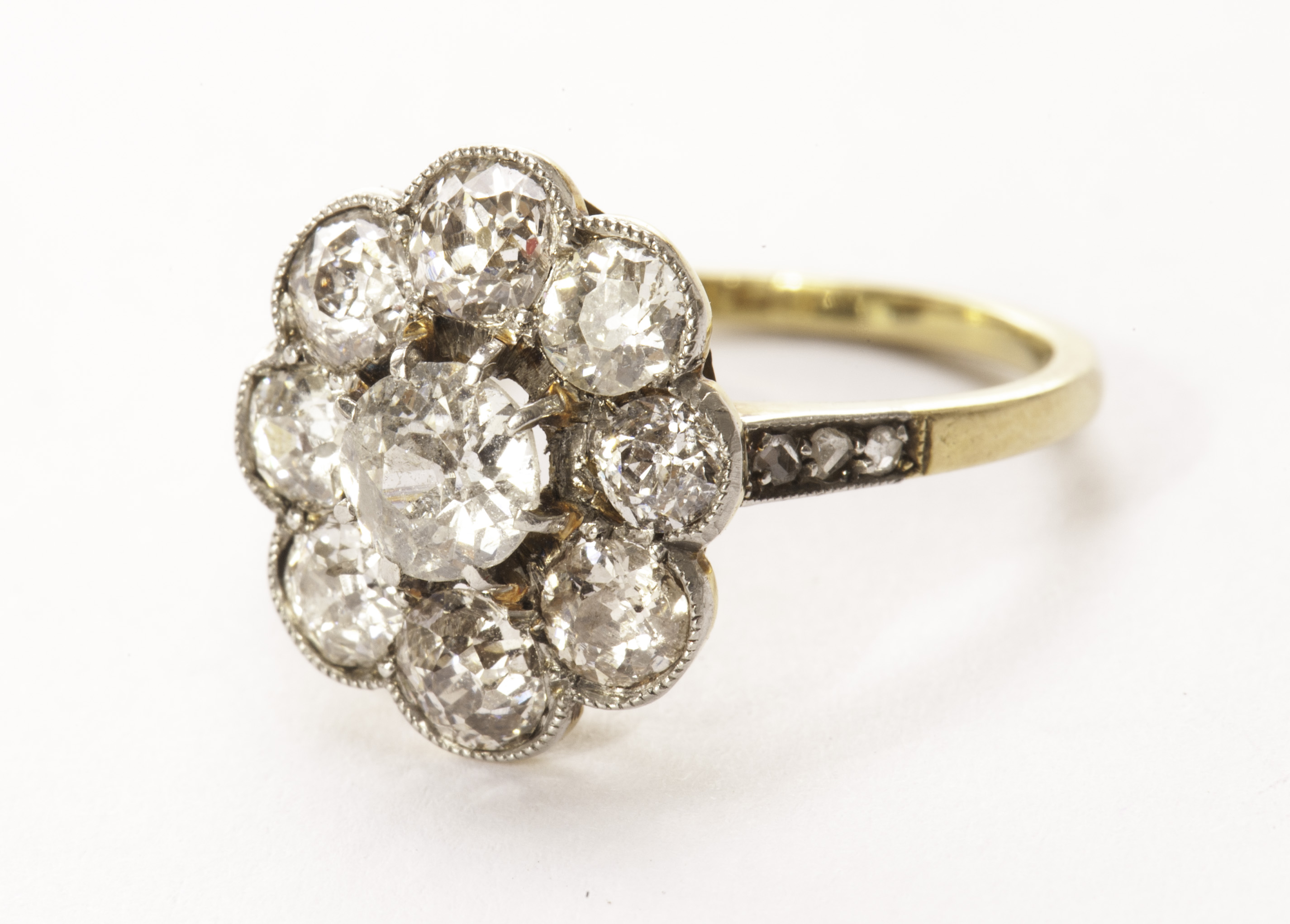 A pretty Edwardian diamond cluster dress ring, the central old cut of approx 0.42ct surrounded by