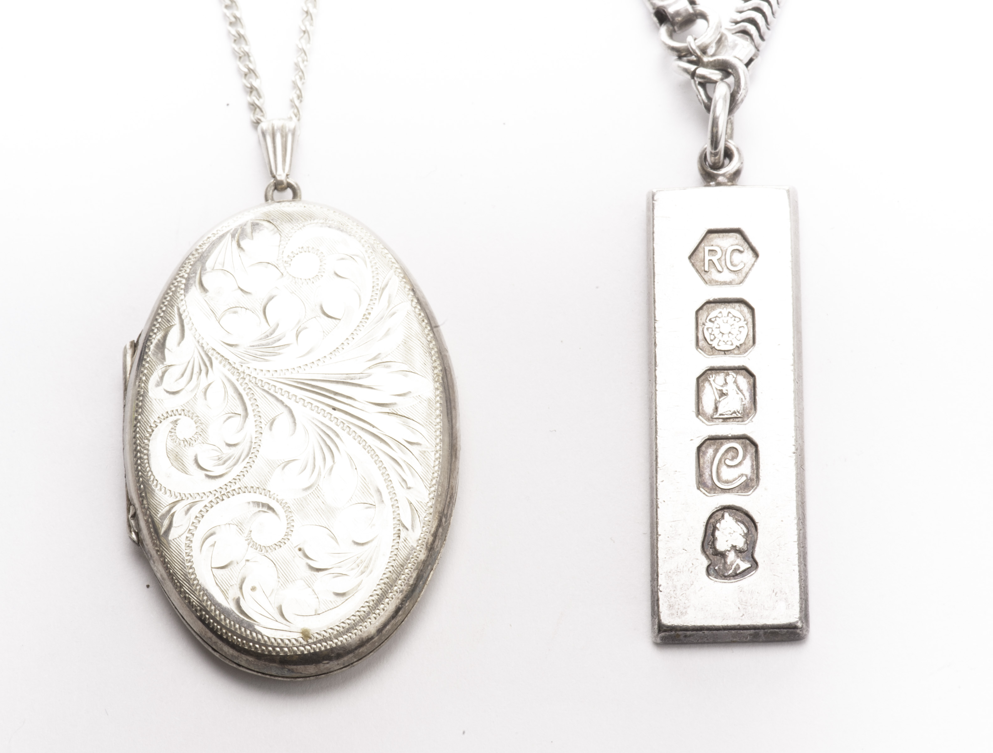 A silver pendant locket, on fine chain necklace, together with a silver ingot pendant on white