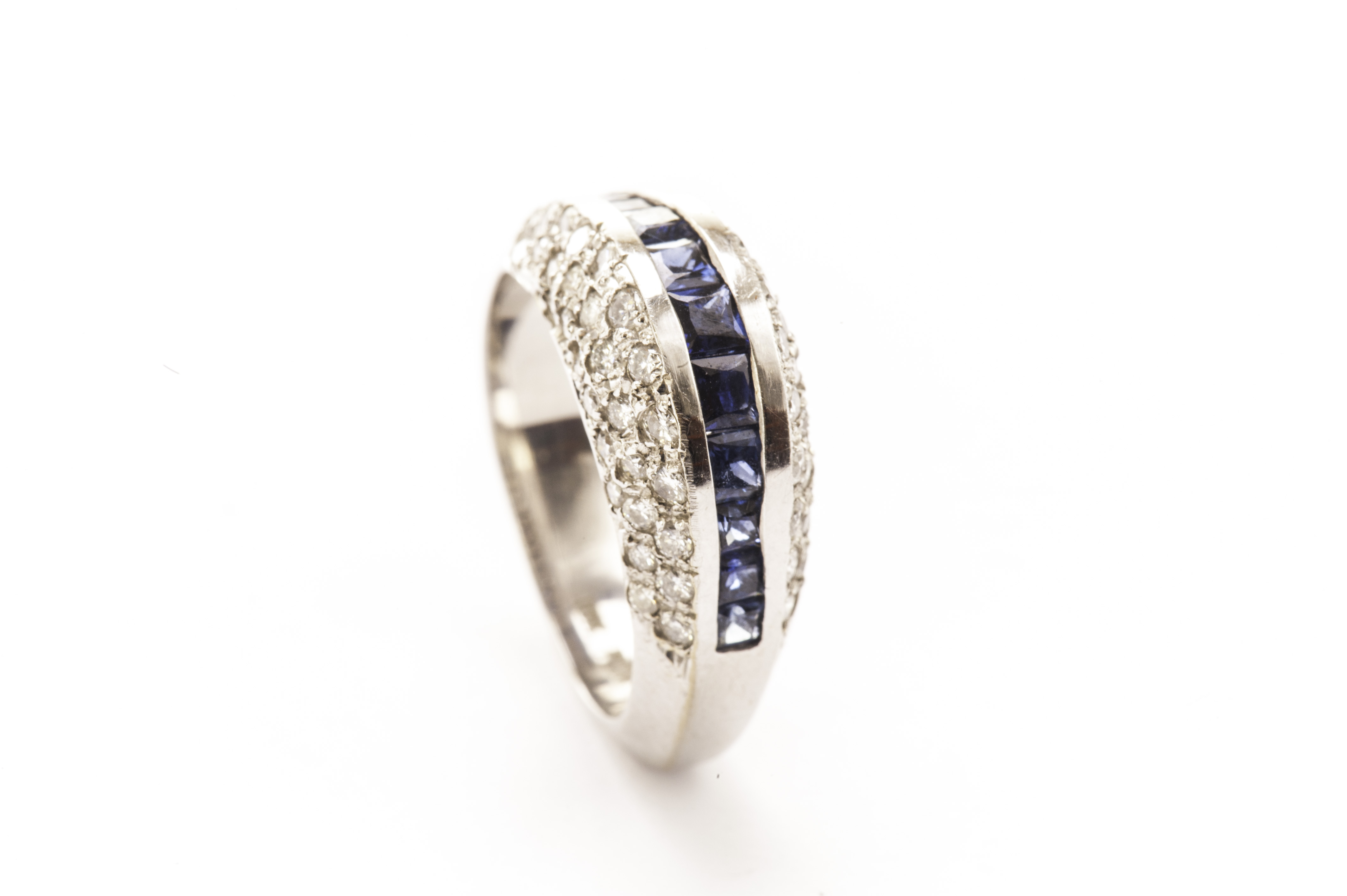A stylish sapphire and diamond dress ring, the bombe tablet with channel set square blue sapphires