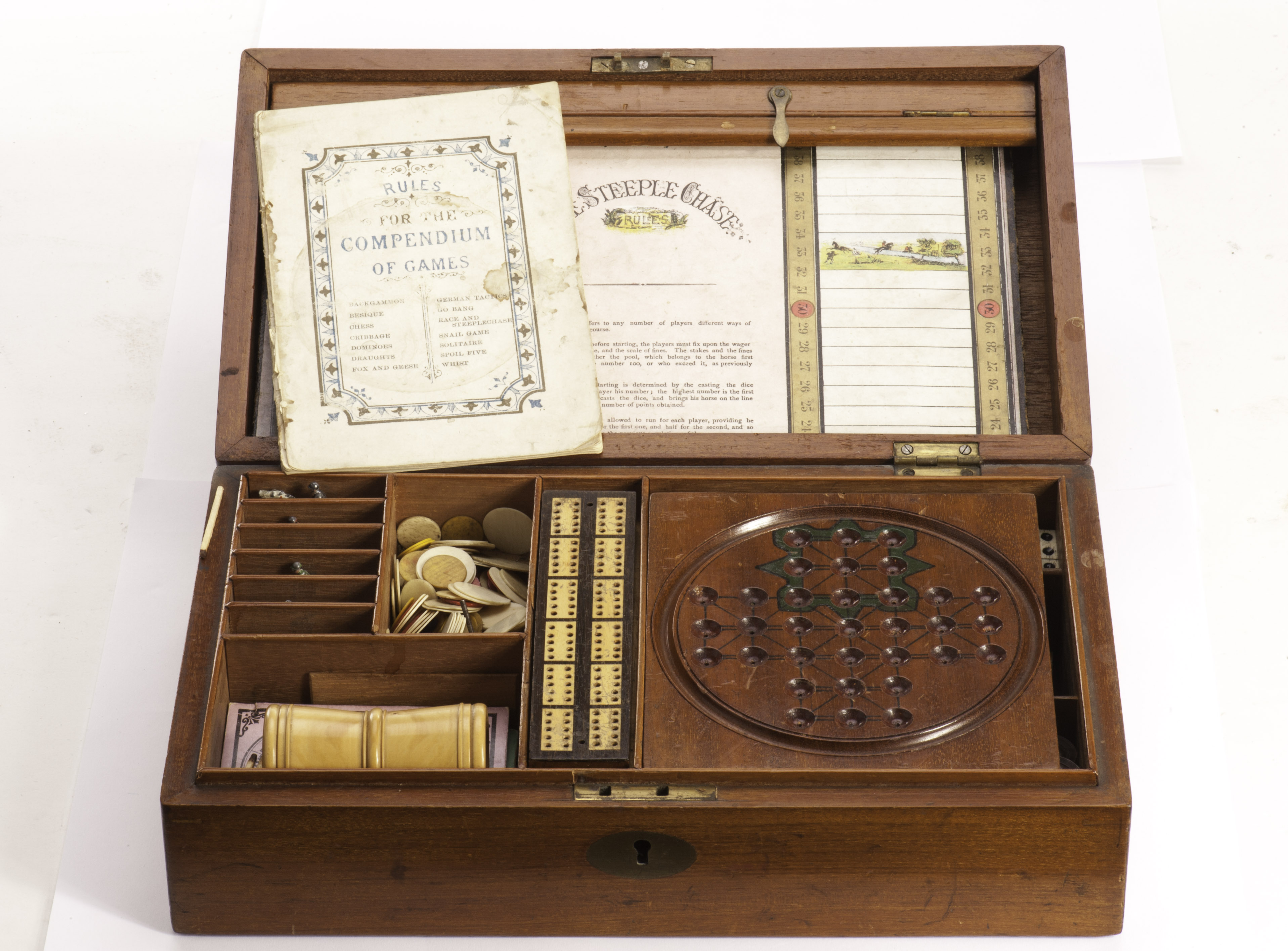 A late Victorian oak cased Compendium of Games from F.H. Ayres, the fitted interior including