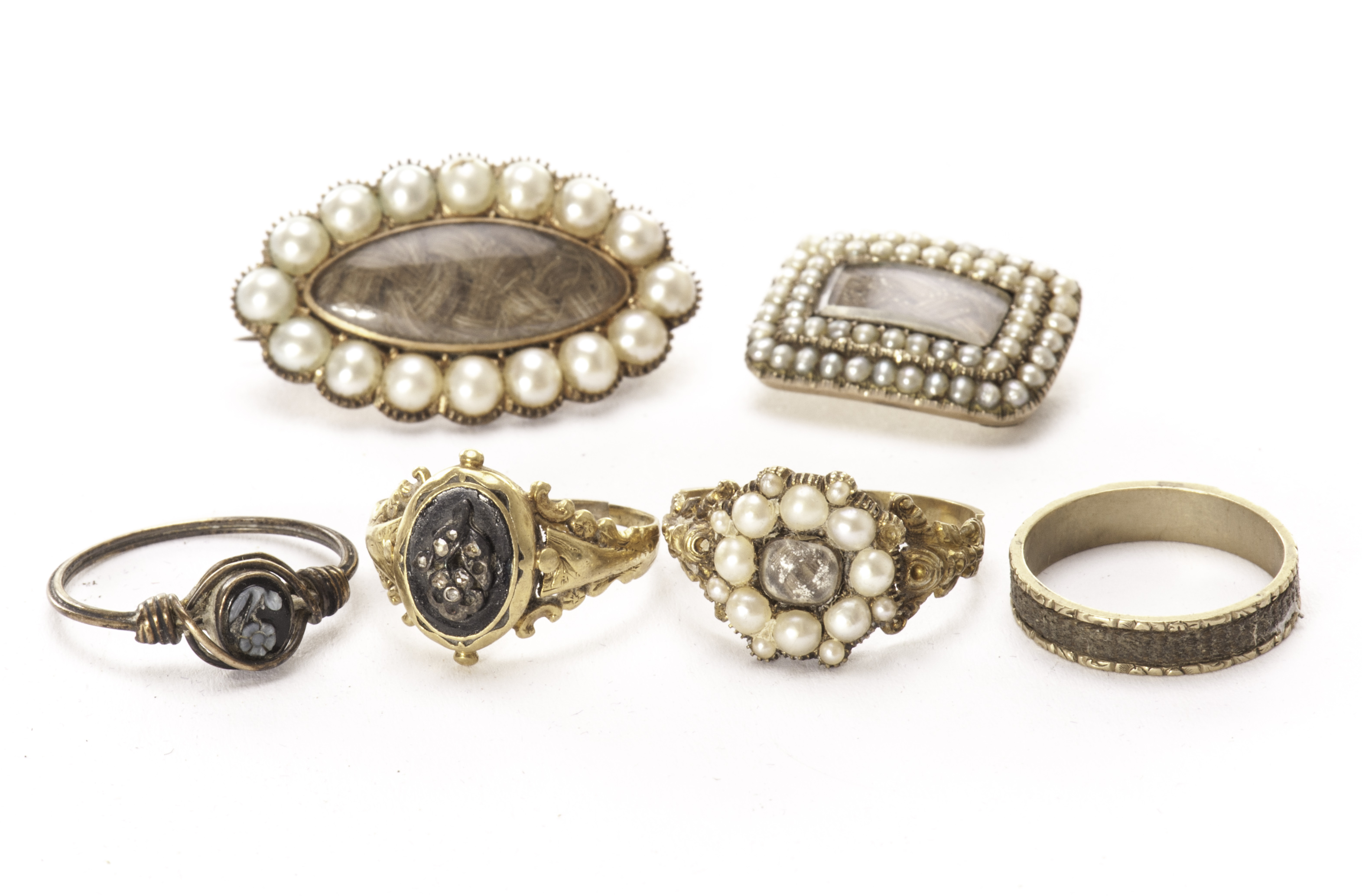 Two early 19th century gold and pearl mourning brooches and four mourning rings, one navette shaped