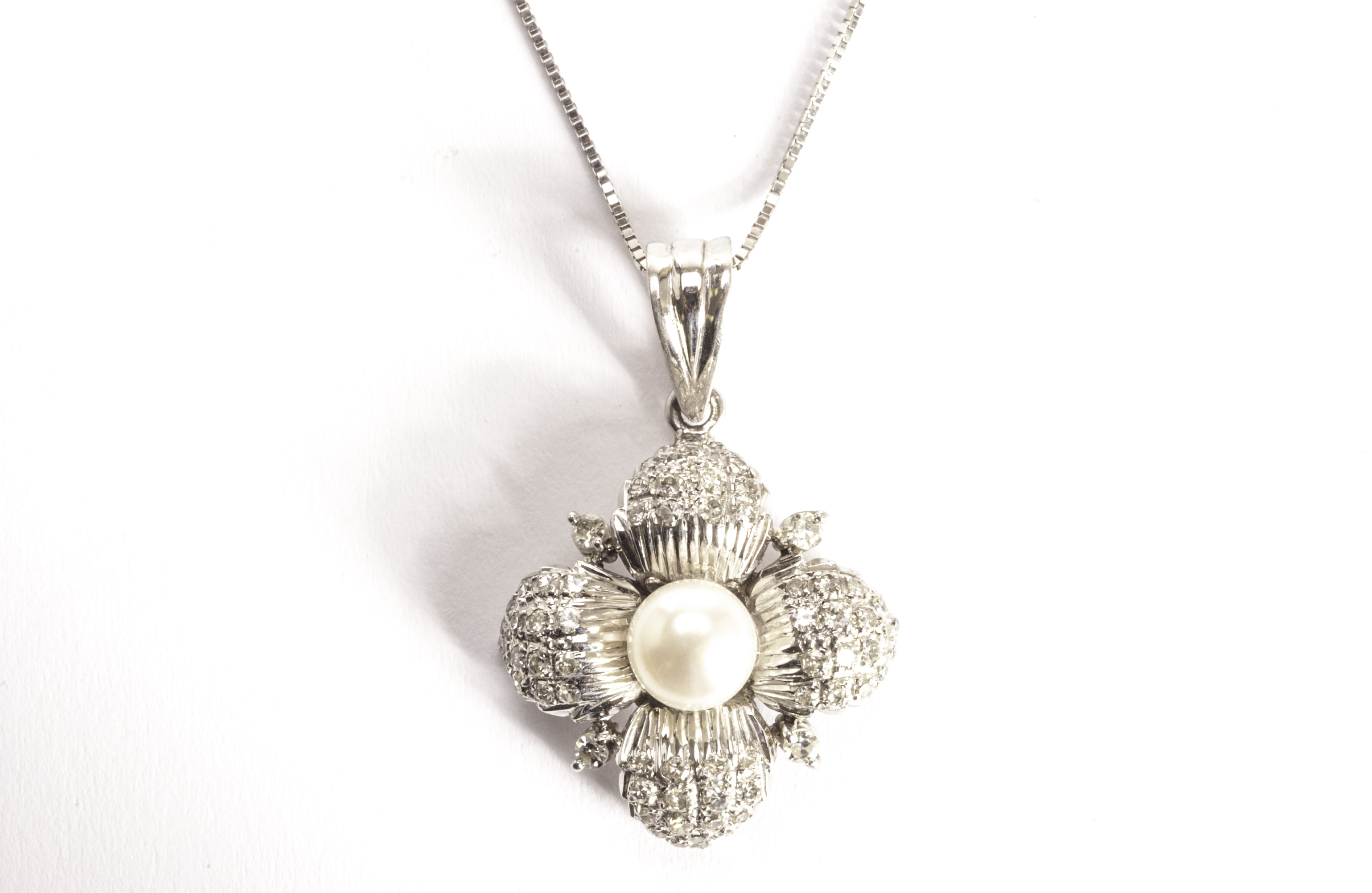 A pretty pearl and diamond pendant necklace, modelled as a flower head with diamond encrusted