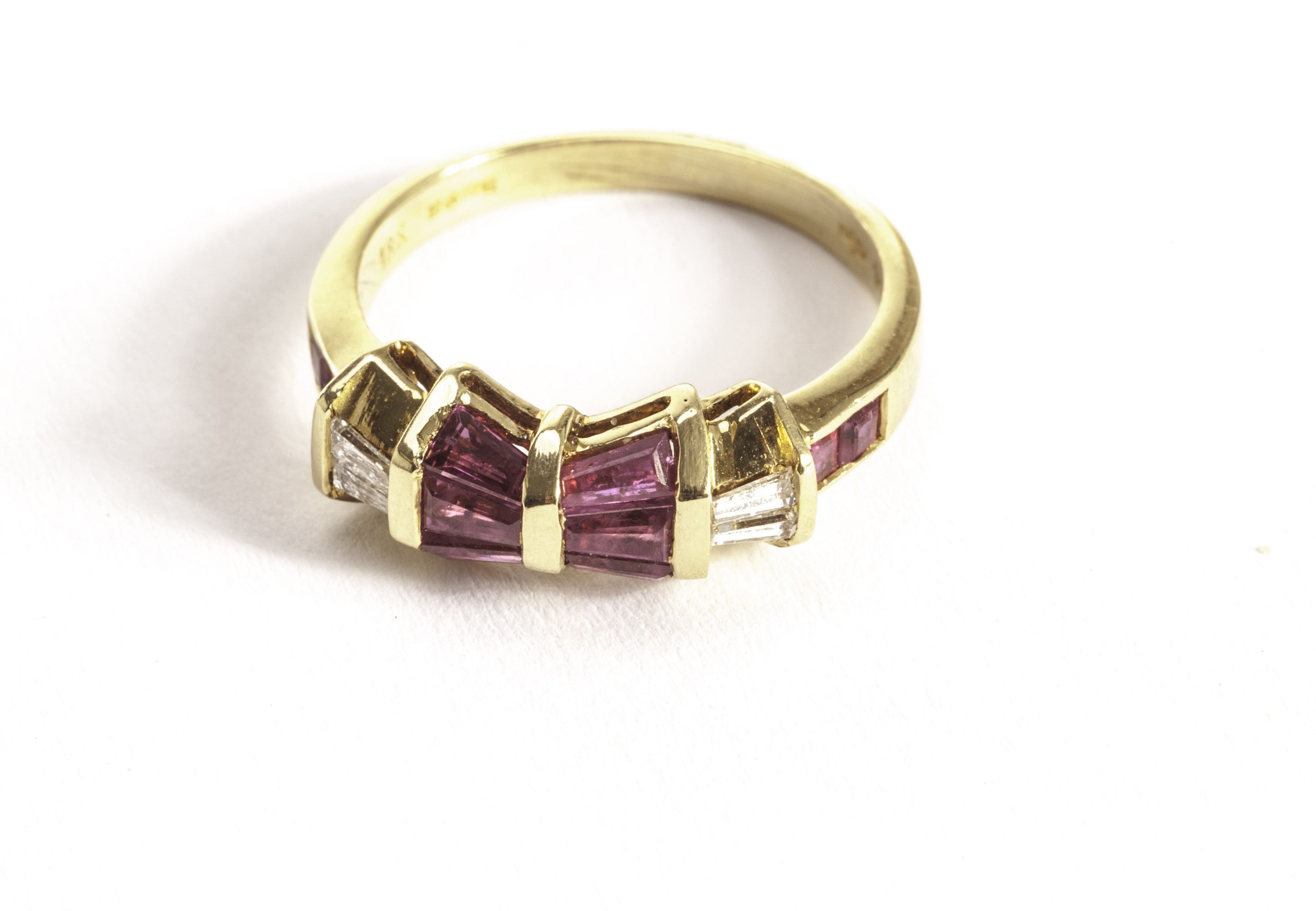 A modern ruby and diamond dress ring, the 18ct gold mount with bow shaped tablet set with tapered