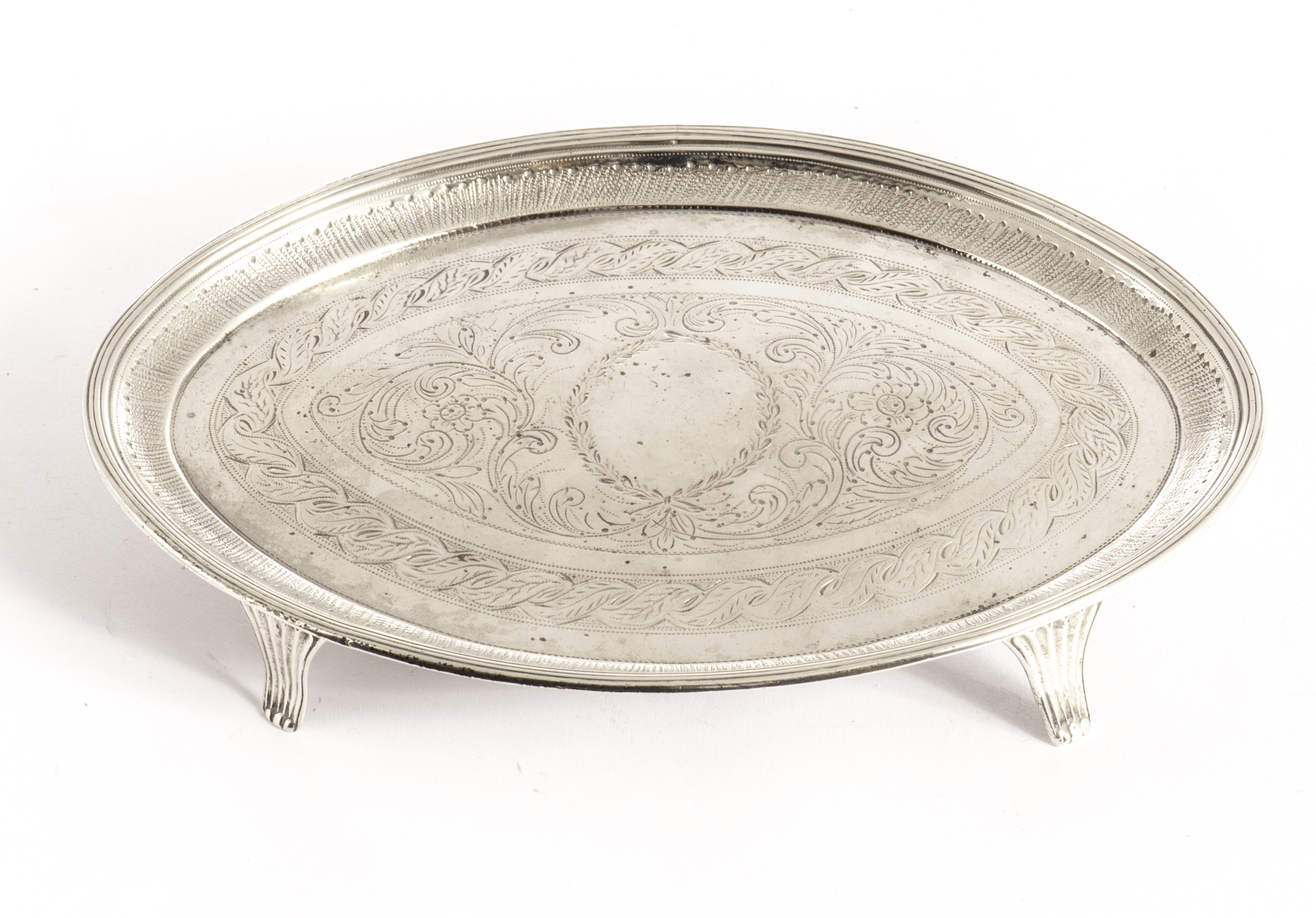 A George III silver teapot stand by Stephen Adams, the oval tray on four scroll supports having