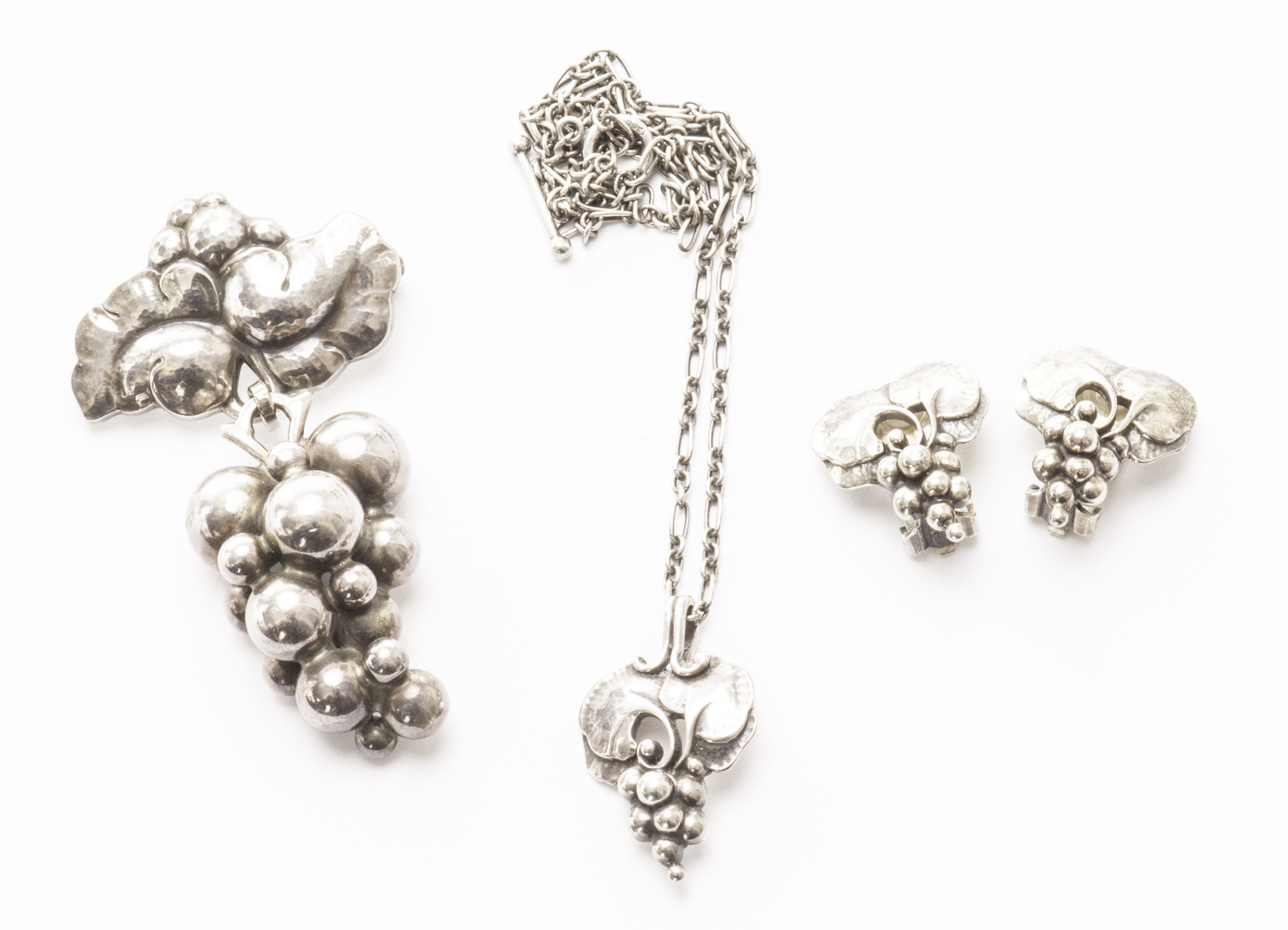 An associated suite of Georg Jensen silver grape and leaf design jewellery, comprising a brooch