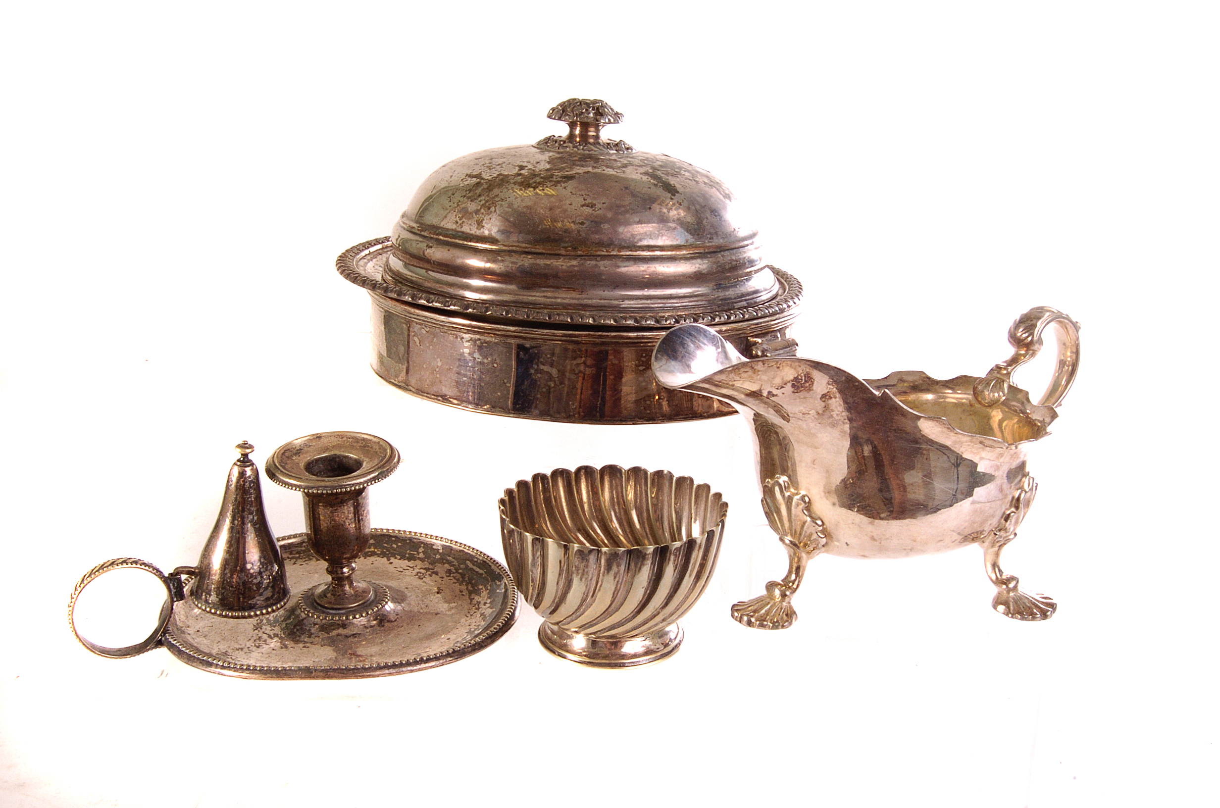 A selection of silver plated items, including a muffin dish, a chamber stick, a wine bottle