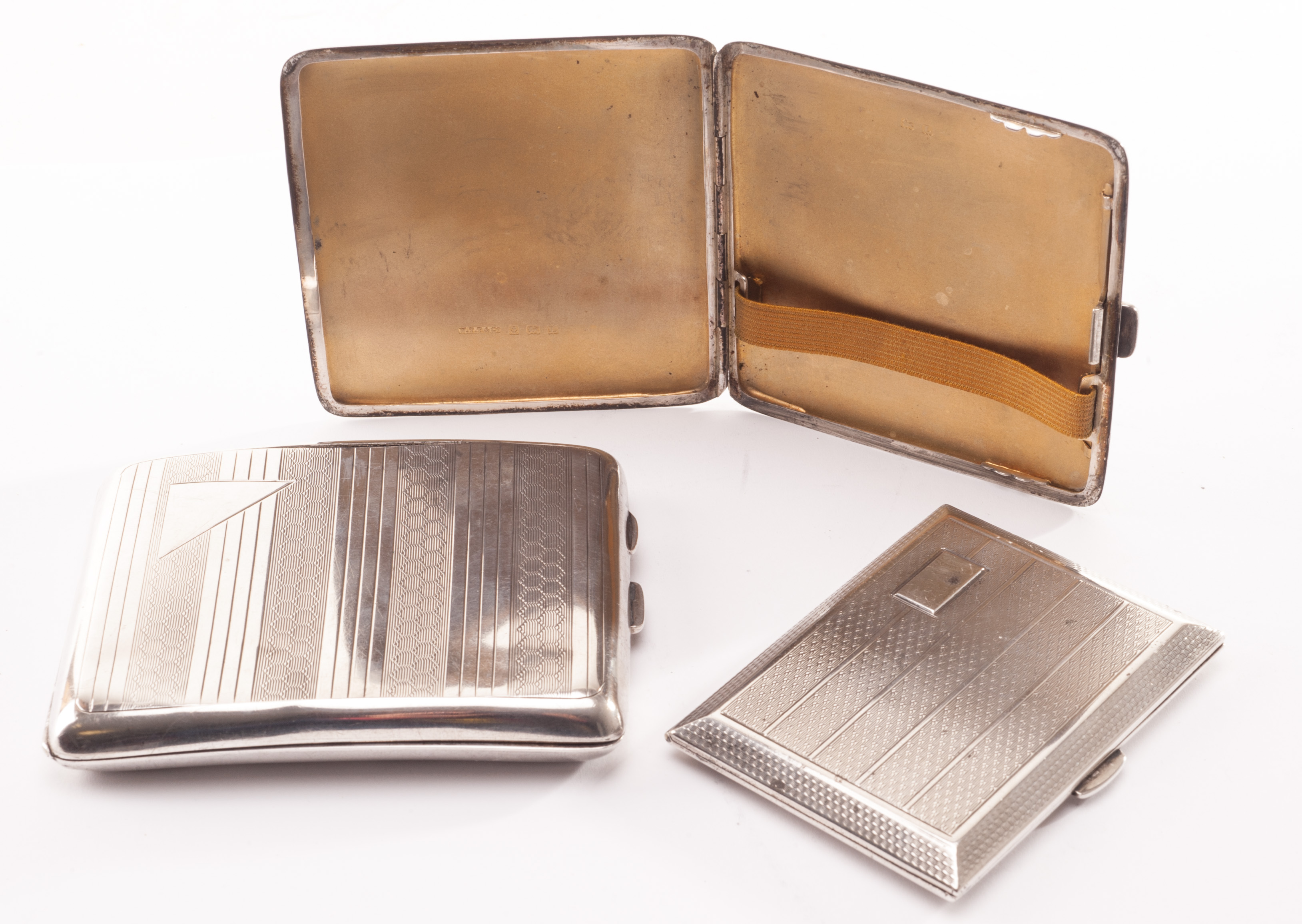 Three silver cigarette cases, all with engine turned decoration and gilt interior, Birmingham 1923,