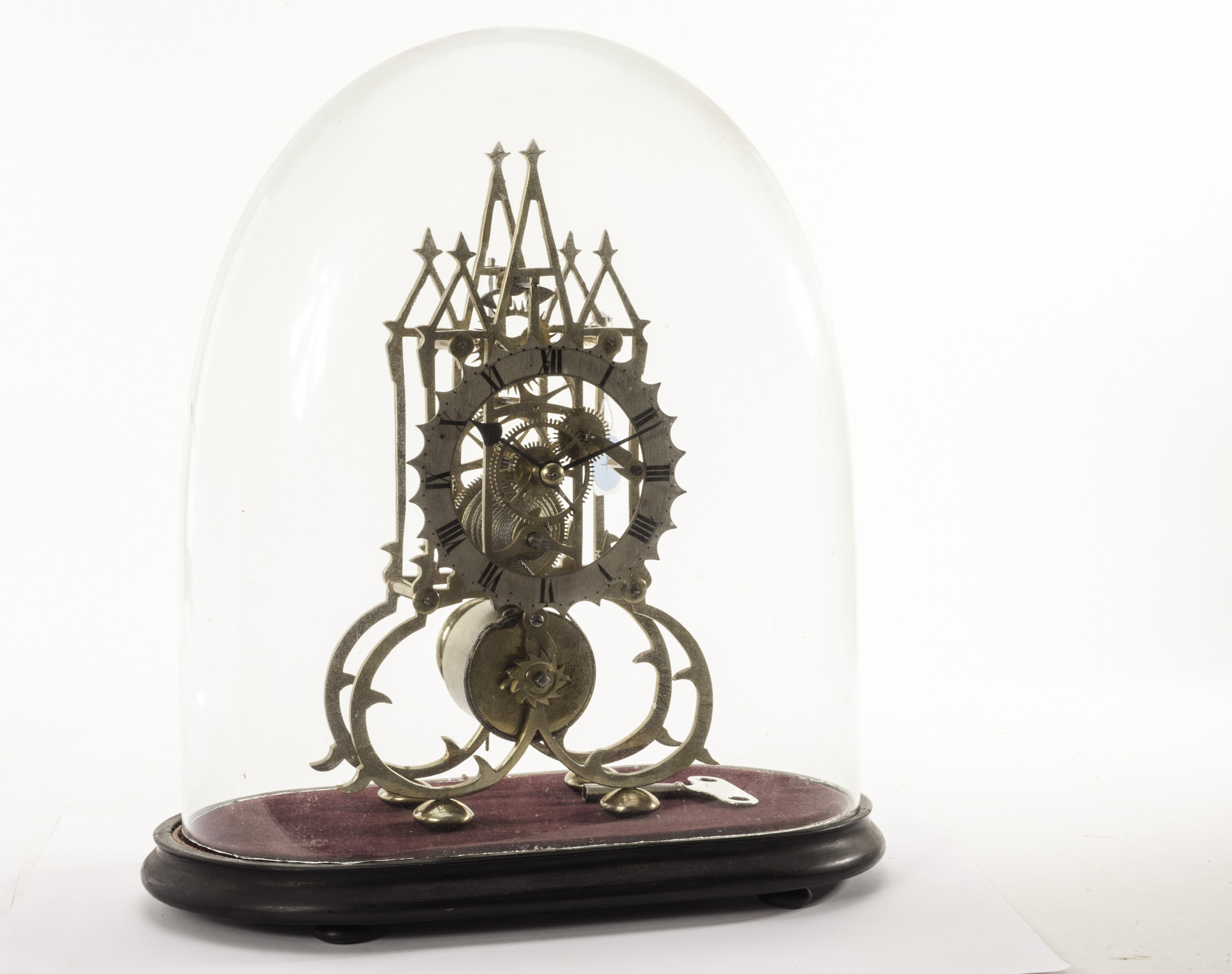 A vintage brass skeleton clock, the Gothic architectural form frame with silvered chapter ring, on