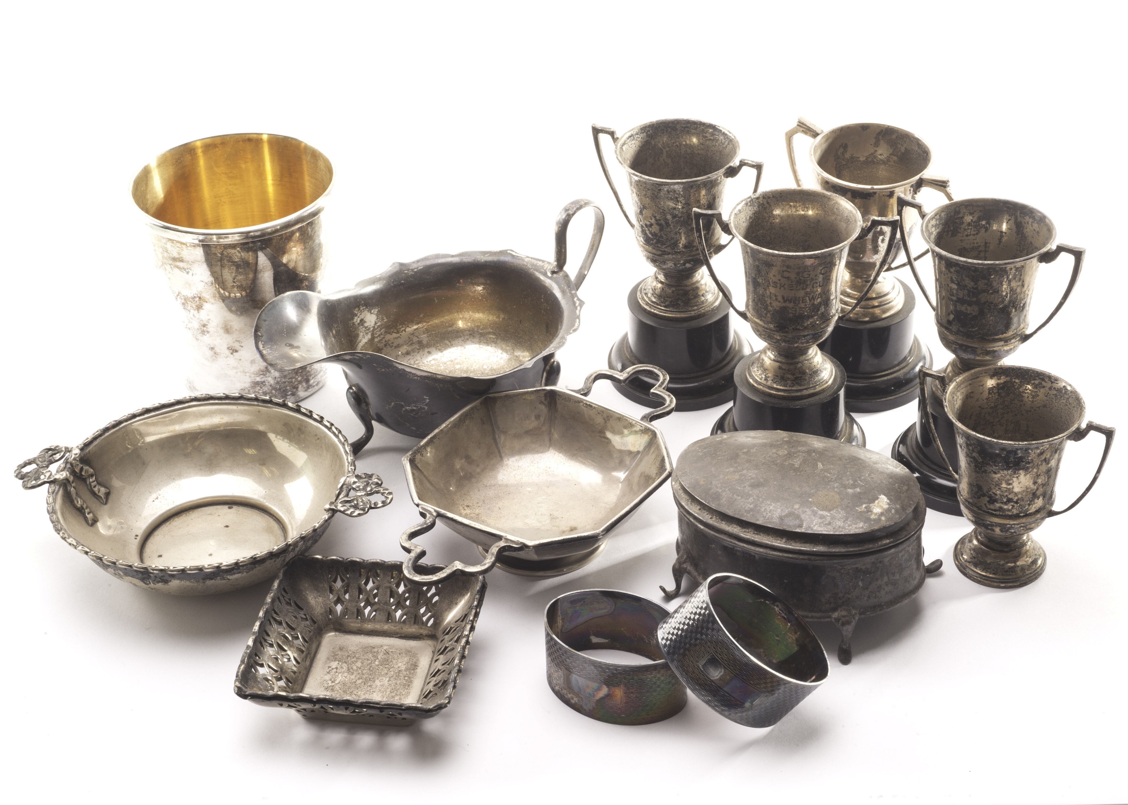 A collection of silver items, including five small George VI trophy cups, a silver sauceboat, a