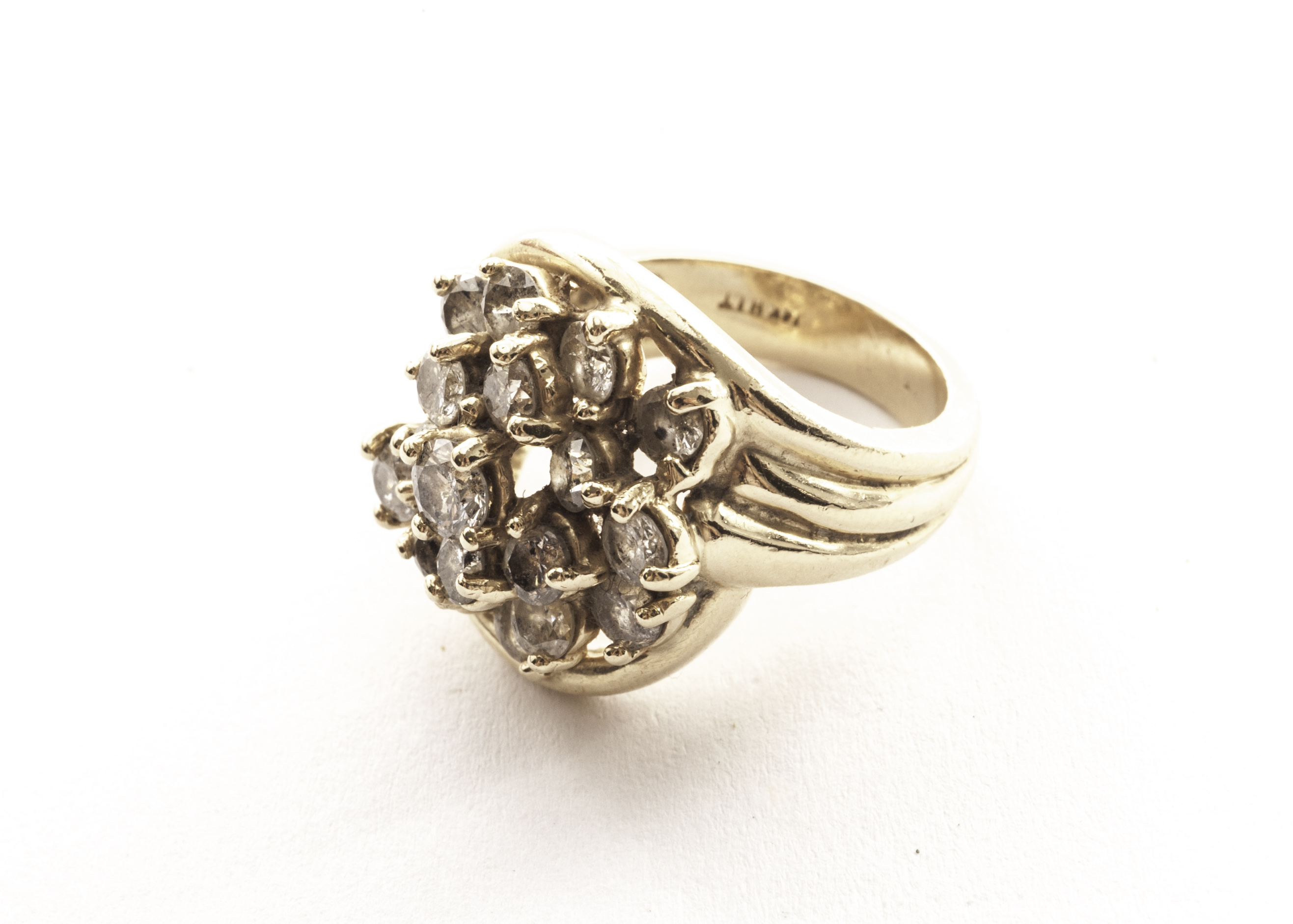 A diamond cluster style dress ring, the modern brilliant cuts in claw set step mount, the inner