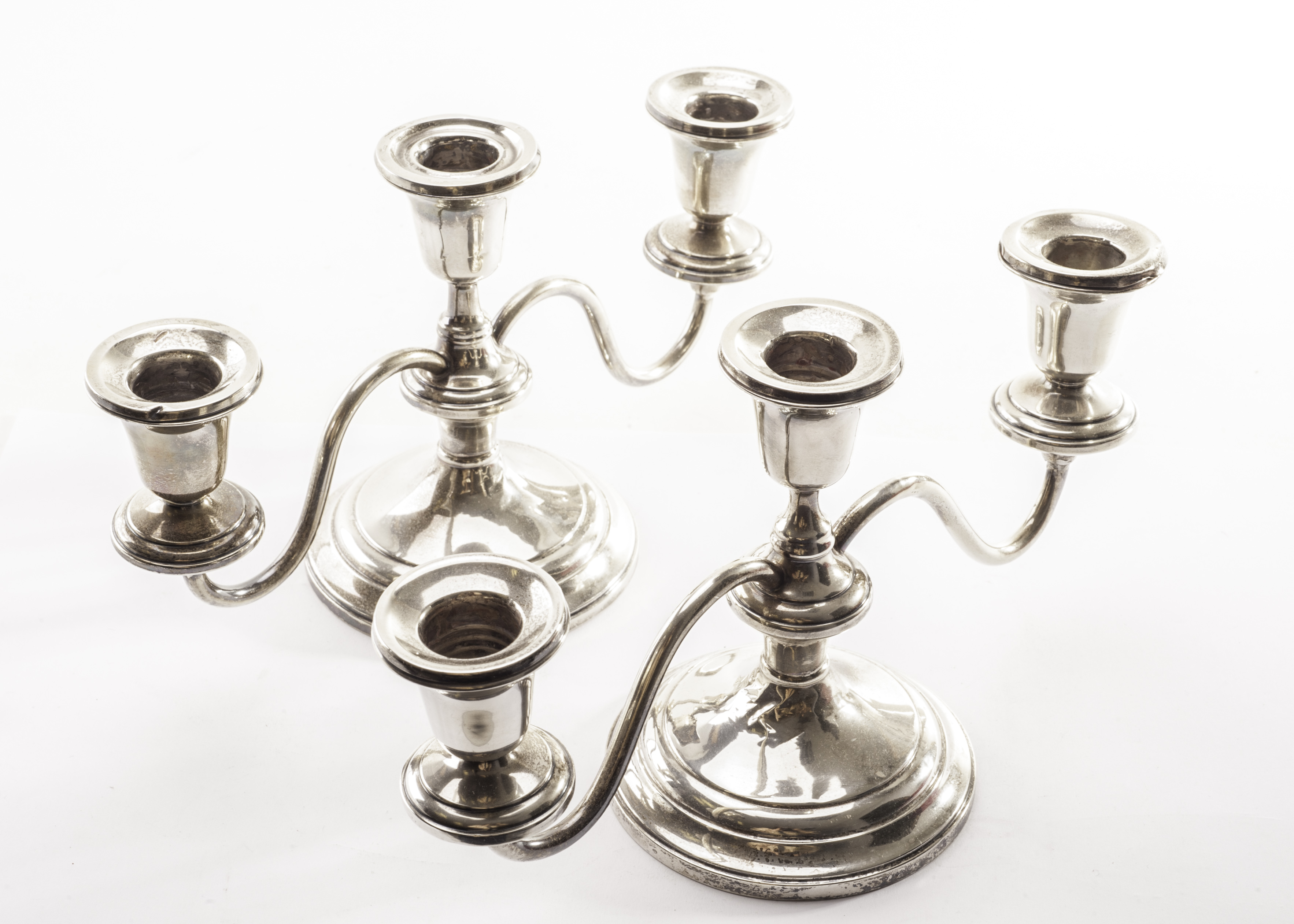 A pair of American sterling silver candelabra by Frank M Whiting, the three branch candleholders on