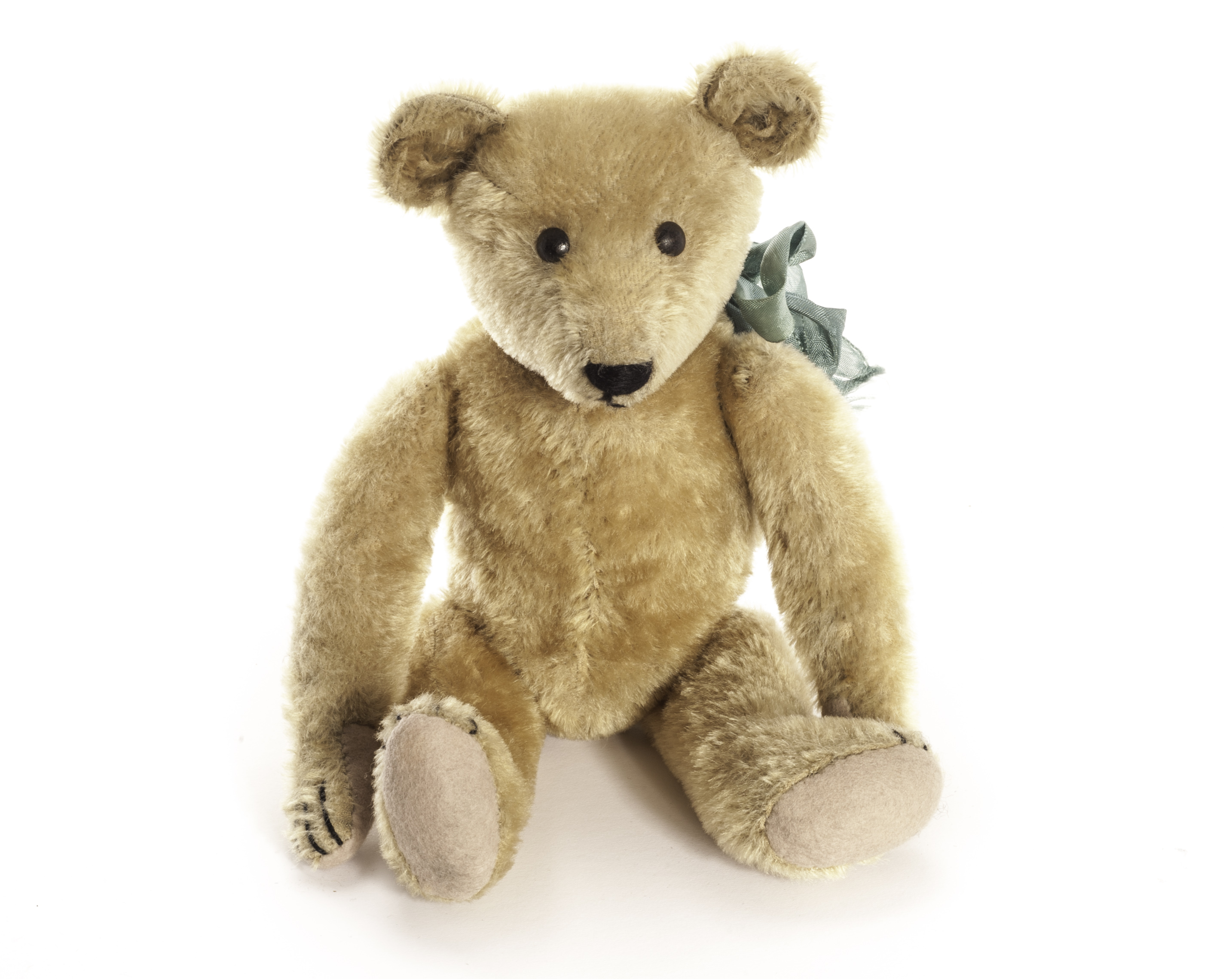 An early English Teddy Bear, circa 1910, with golden mohair, black painted tin eyes, slotted-in