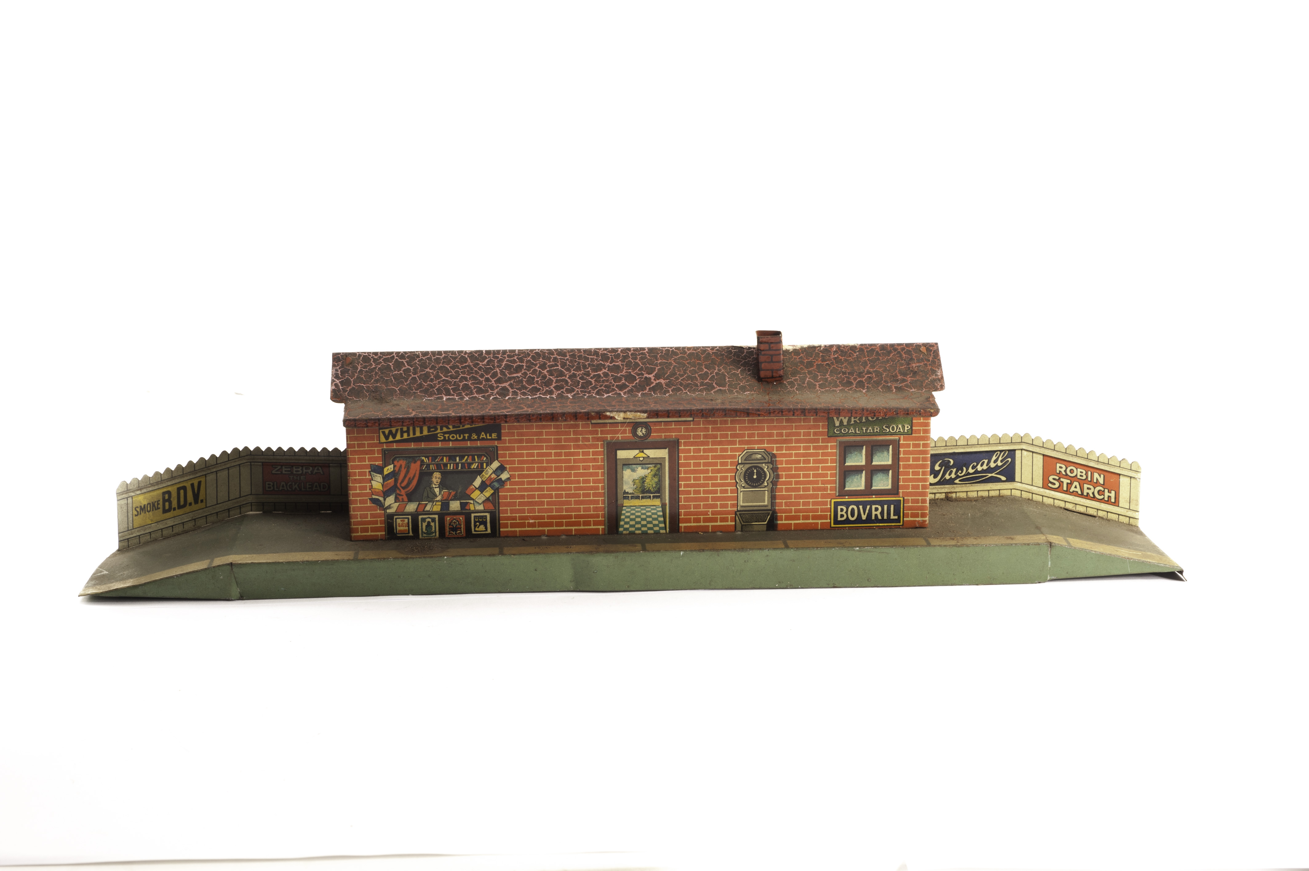 A Bing 0 Gauge Station, with litho, fencing, Kiosk and various adverts, G, crazing to roof and some
