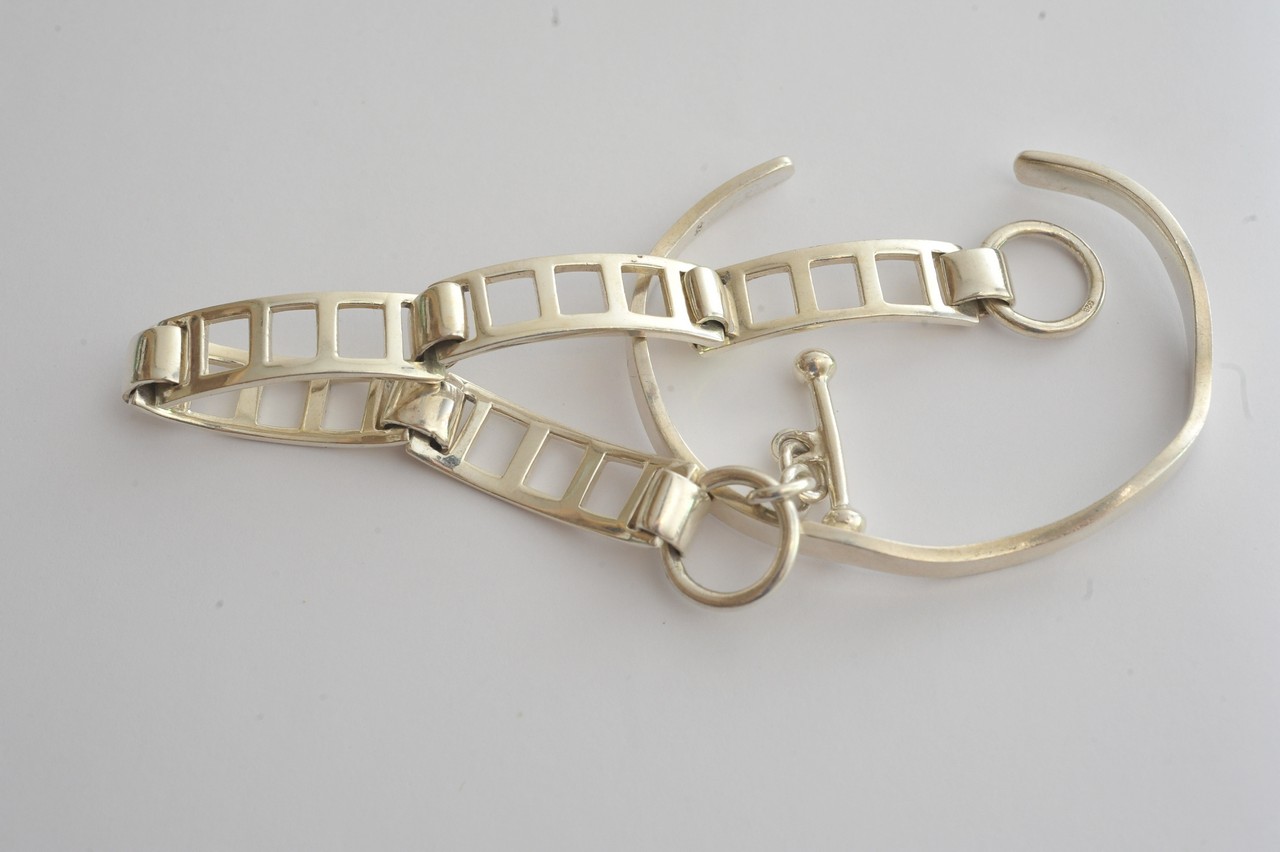 A silver torque bangle together with a silver panel bracelet
