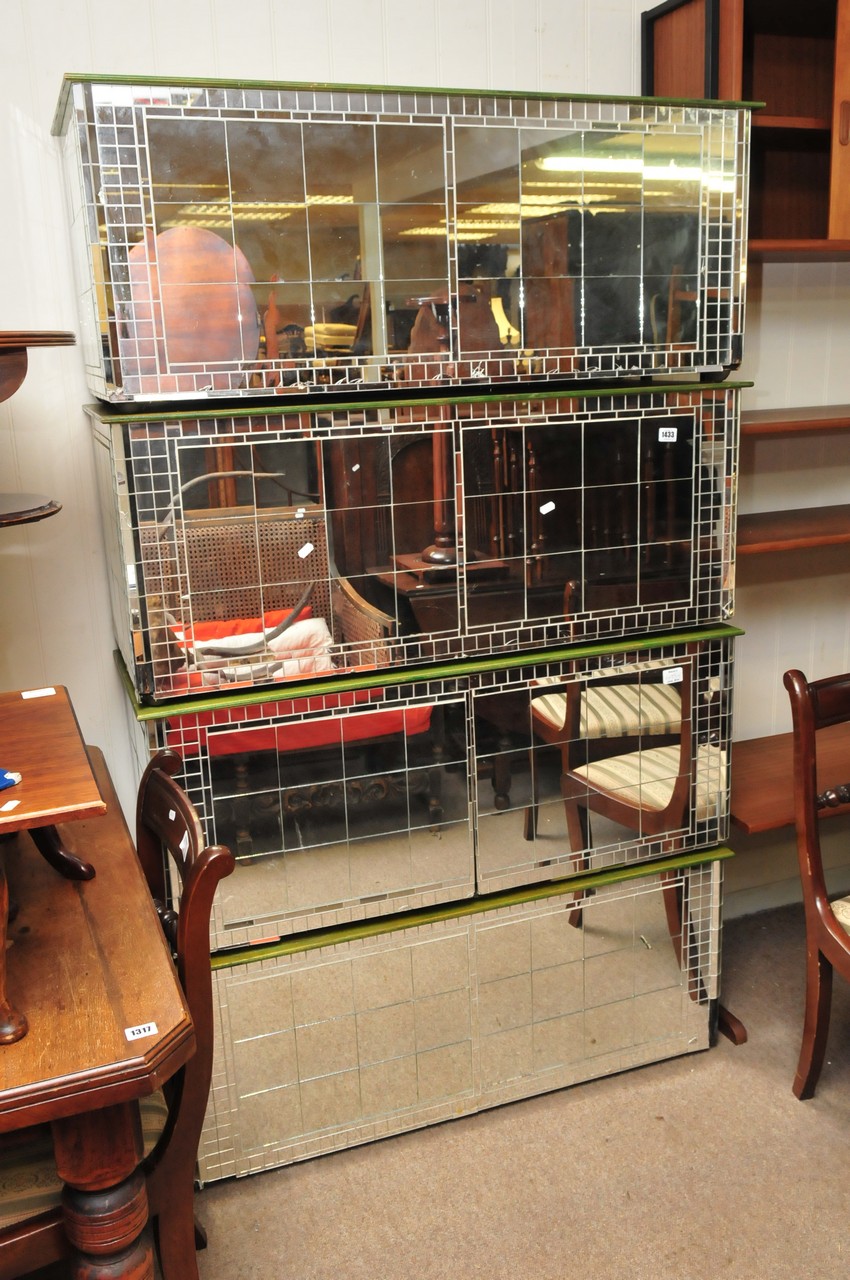 A collection of four mirrored, painted storage boxes