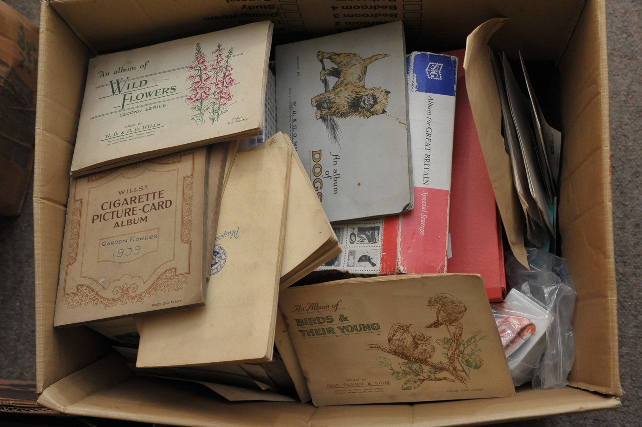 A box of postcards, cigarette cads and stamps