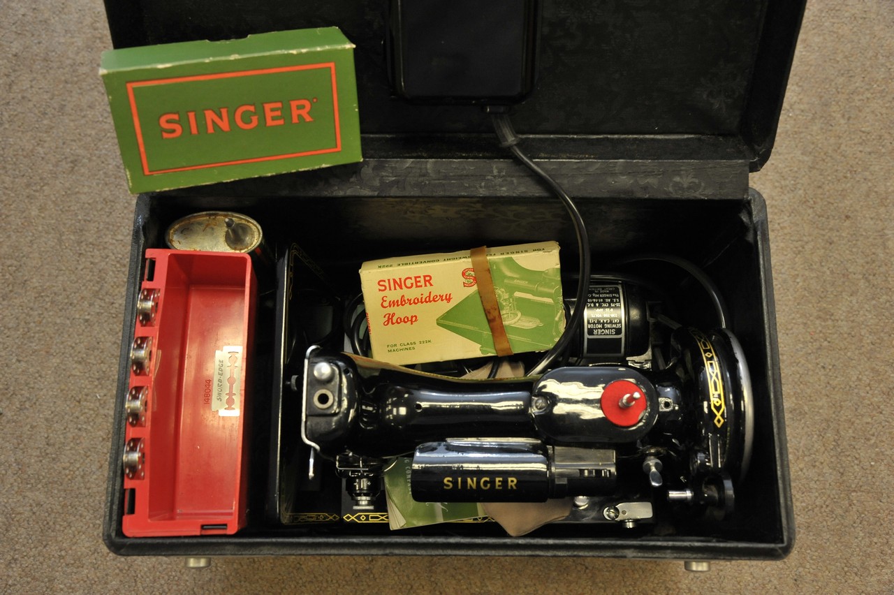 A small portable Singer sewing machine in case with accessories